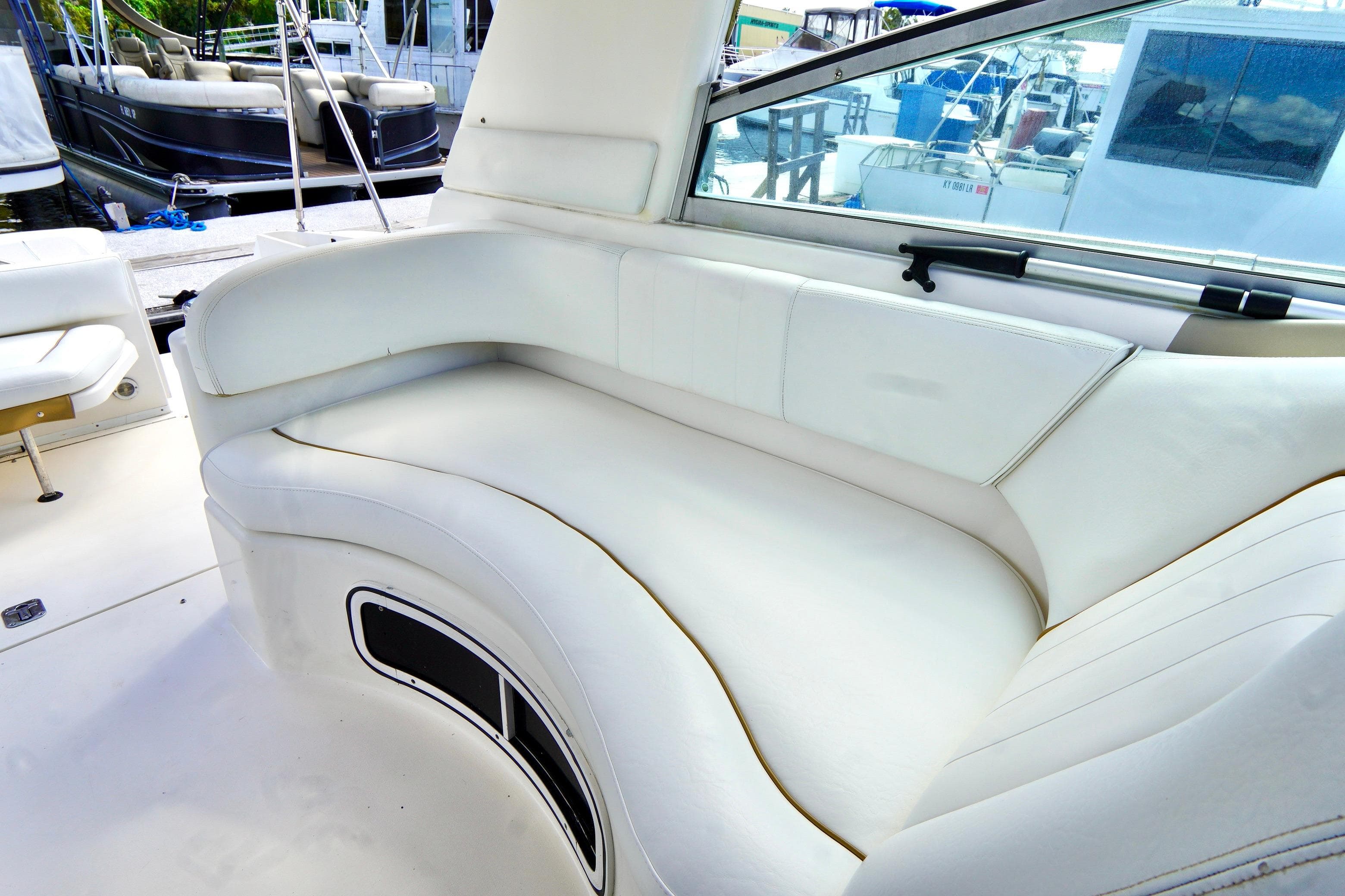 Interior seating of 2000 Sea Ray 280 Sundancer boat, featuring white leather upholstery.
