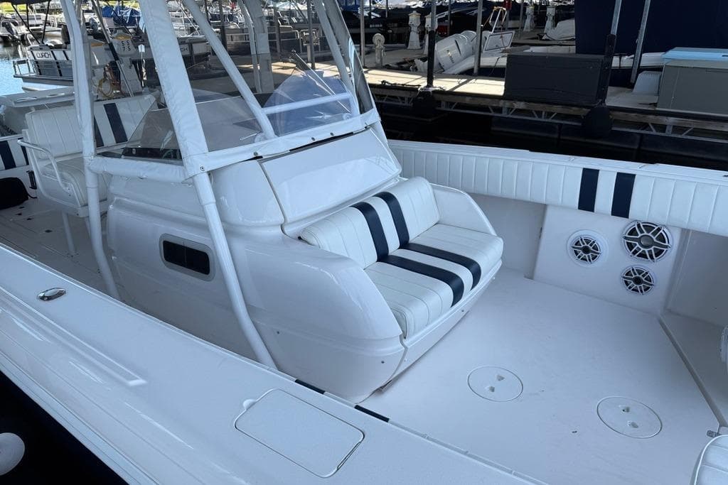2005 Intrepid 370 Center Console boat with white seating and striped cushions at a marina.