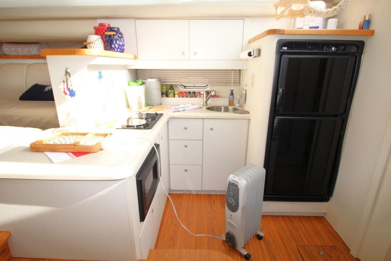 1997 Cruisers Yachts 3650 Motoryacht interior kitchen with appliances and wooden flooring.