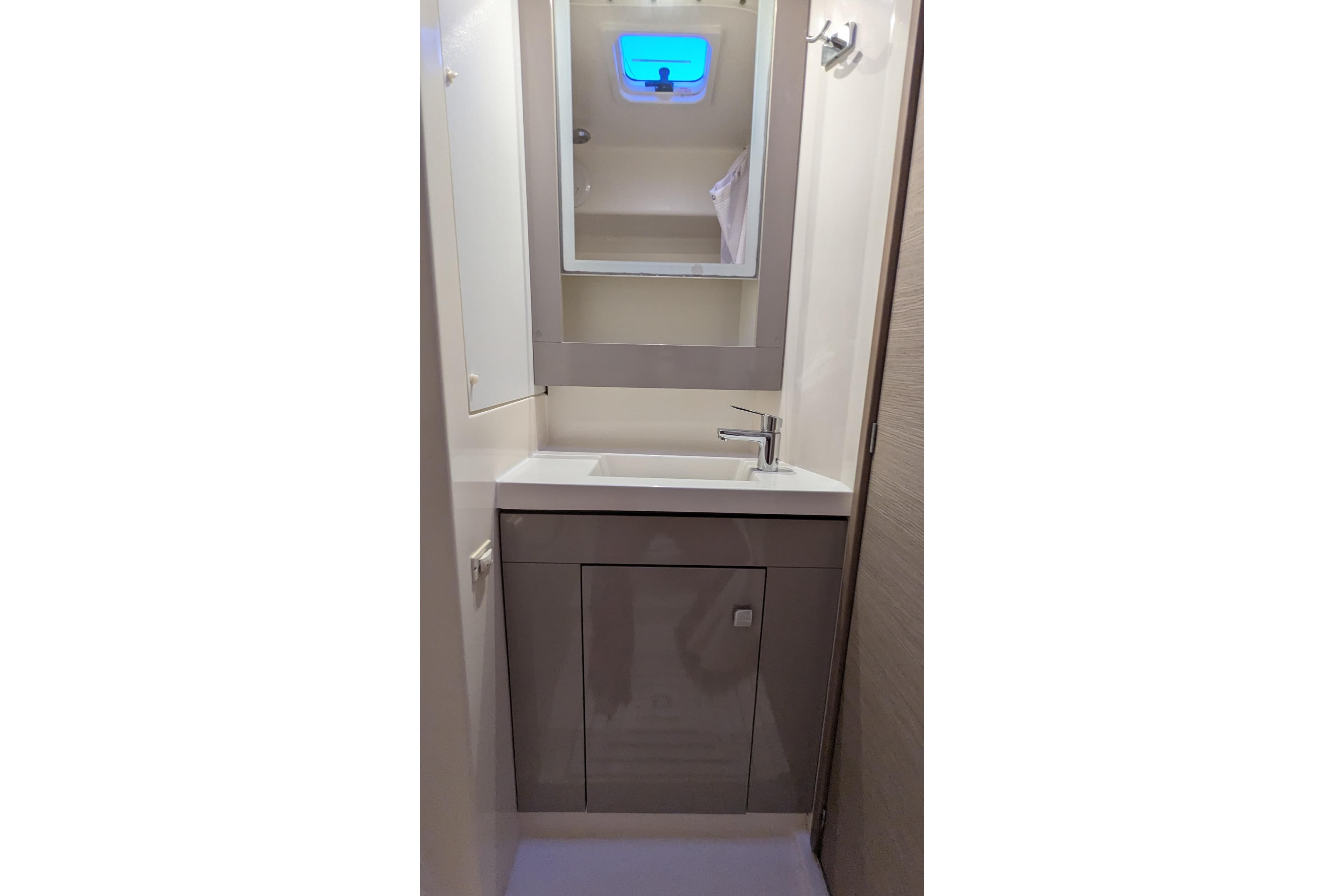 Bathroom vanity in 2020 Fountaine Pajot Saona 47 yacht, featuring modern sink and mirror.