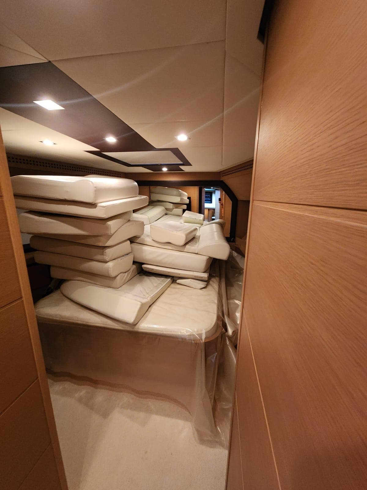 Interior of 2011 Pershing 72 yacht with stacked cushions in a cabin.