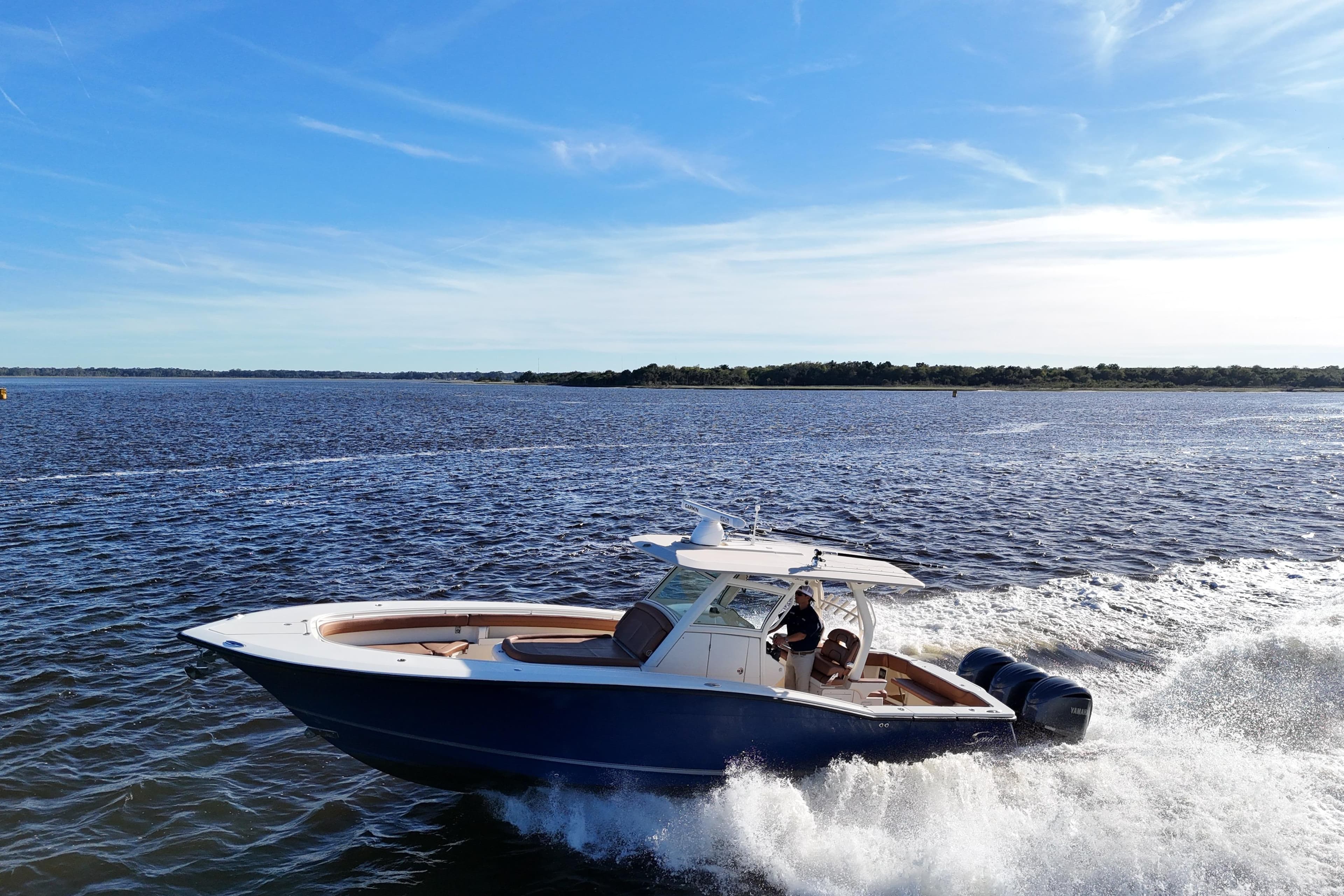 2017 Scout 350 LXF boat cruising on open water under a clear blue sky.