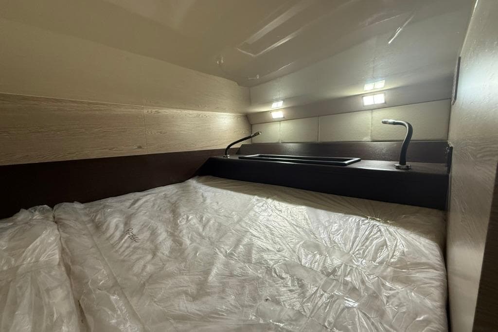 Cozy cabin interior of 2017 SACS Rebel 47 with modern lighting and bedding.