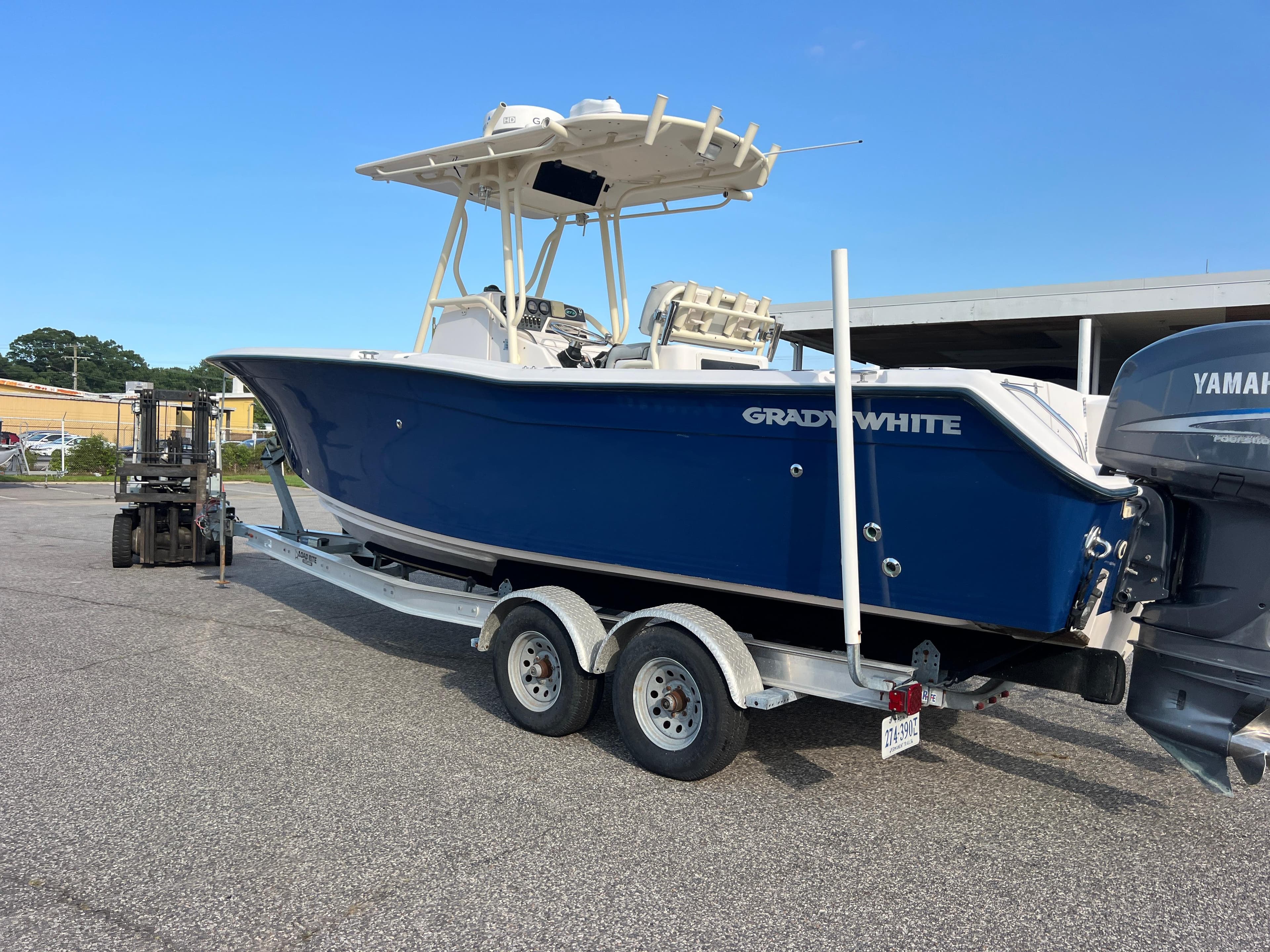 2002 Grady-White Chase 273 boat on trailer, blue hull, parked outdoors.