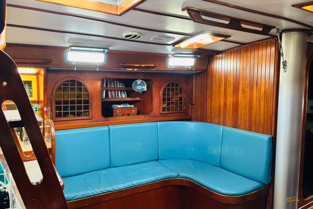 Interior of 1982 Stevens 47 yacht with blue seating and wooden paneling.