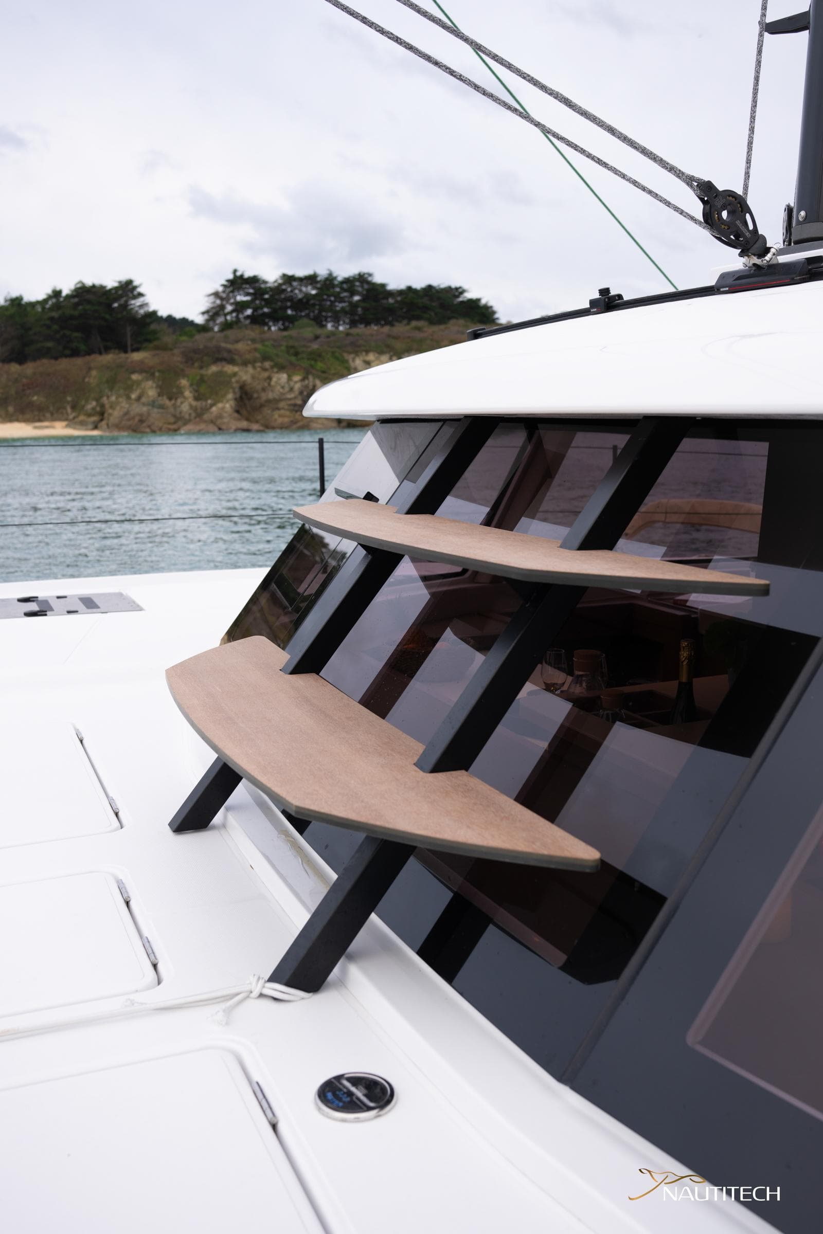 2025 Nautitech 48 Open yacht with sleek design and modern windows, docked by the shore.