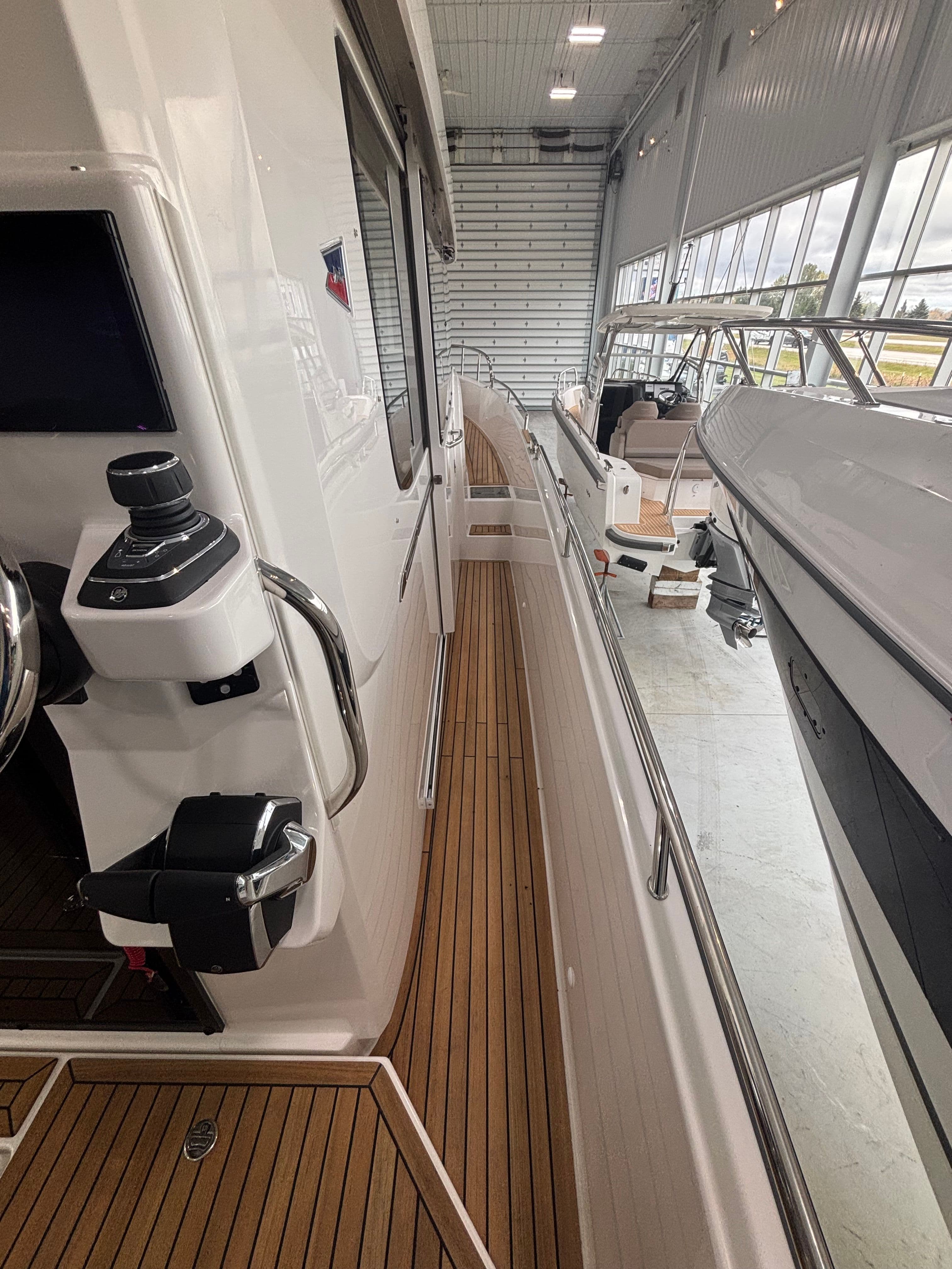Nimbus Commuter 11 MKII Legacy Edition 2026 in a showroom, showcasing sleek design and wooden deck.