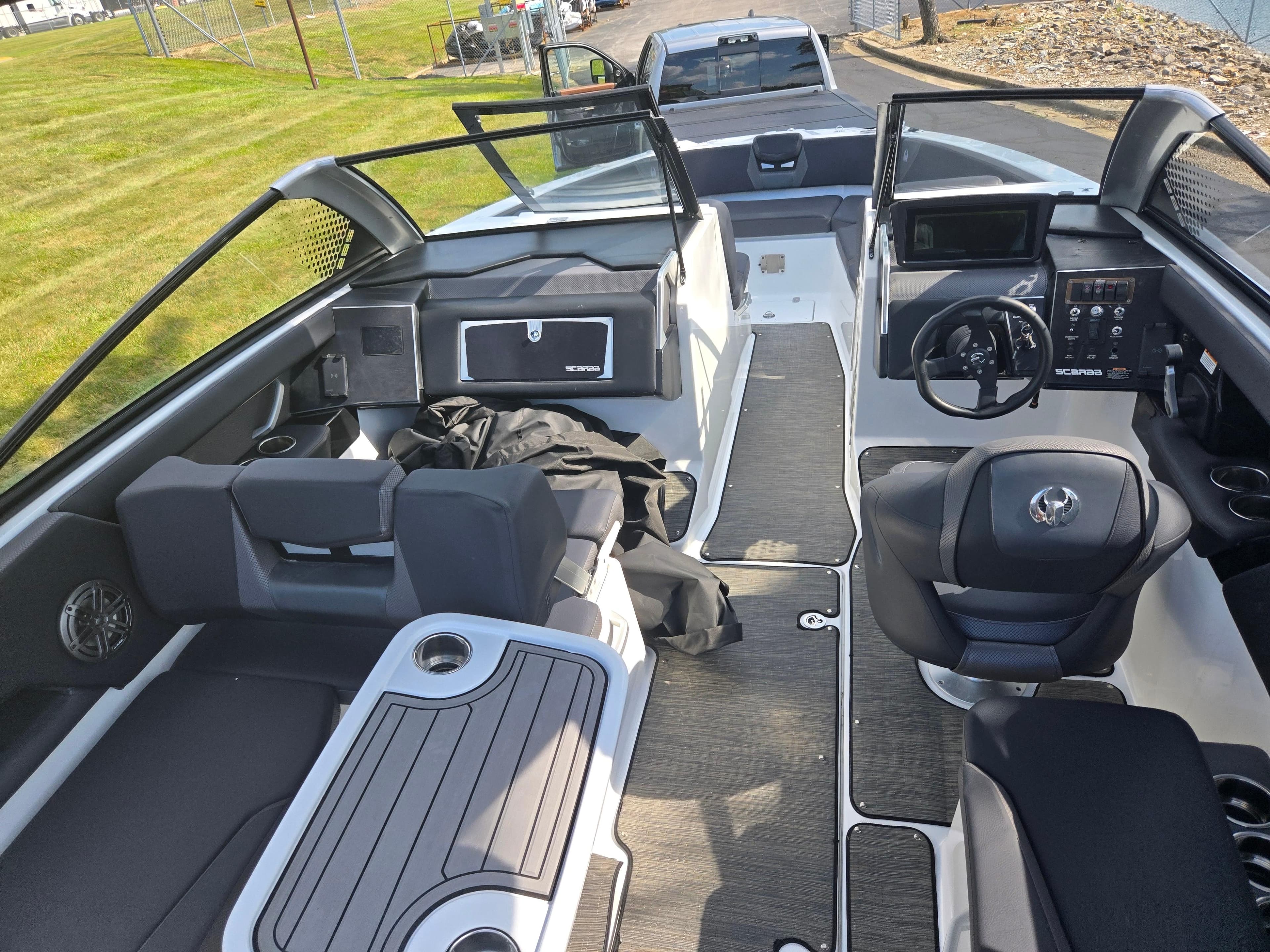 2021 Scarab 285 ID boat interior with seating, steering wheel, and dashboard.
