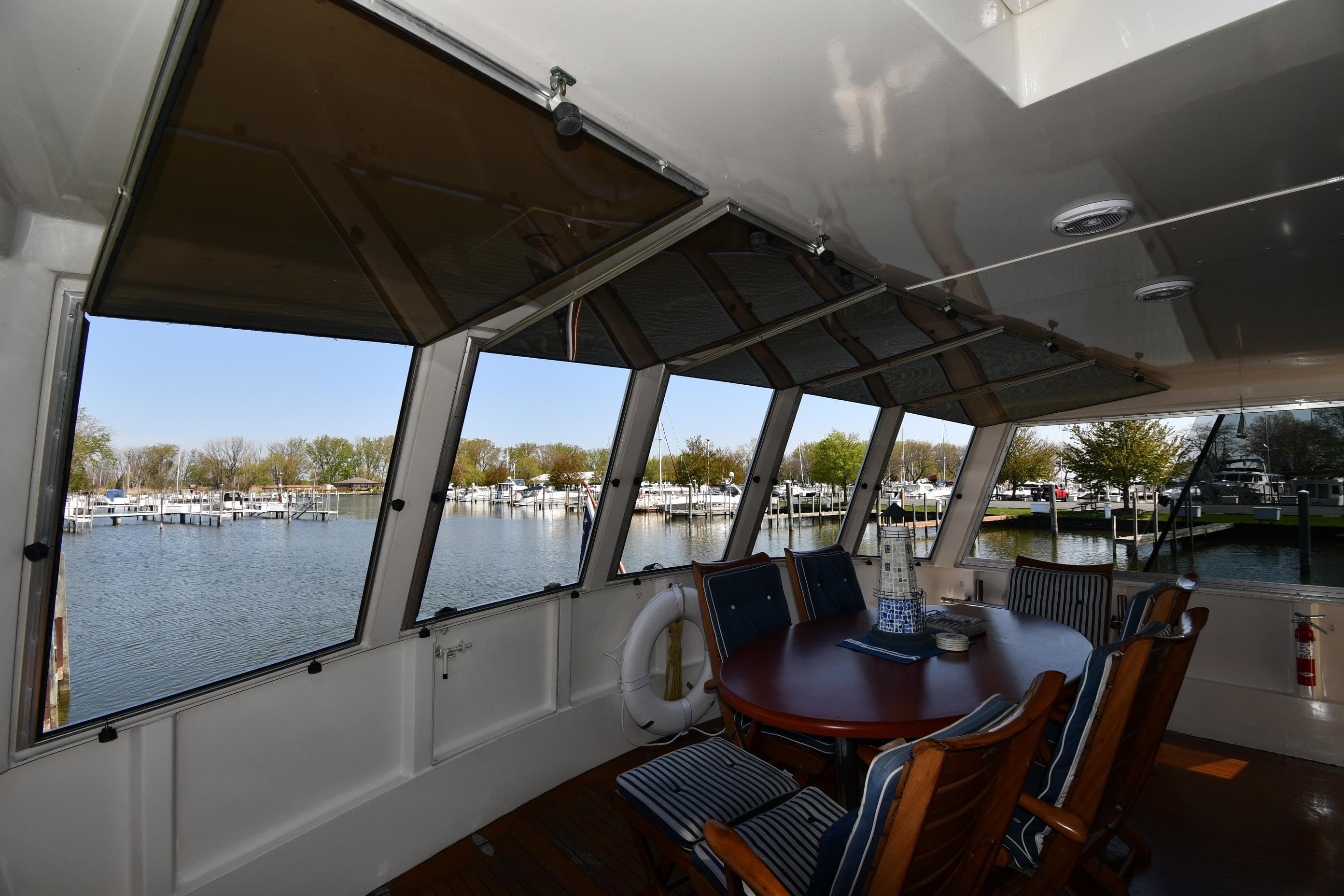 Enclosed deck area of 1986 Lowland 64 Pilot House Long Range Motor Yacht with marina view.