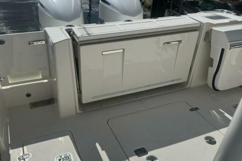 2020 Pursuit S 328 Sport boat deck with storage compartments and dual engines.