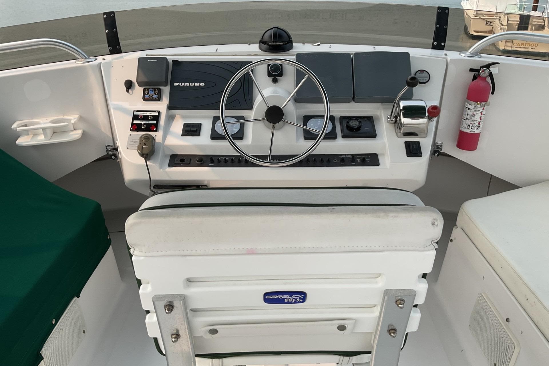 1999 Mainship 350 Trawler helm with steering wheel, controls, and navigation equipment.