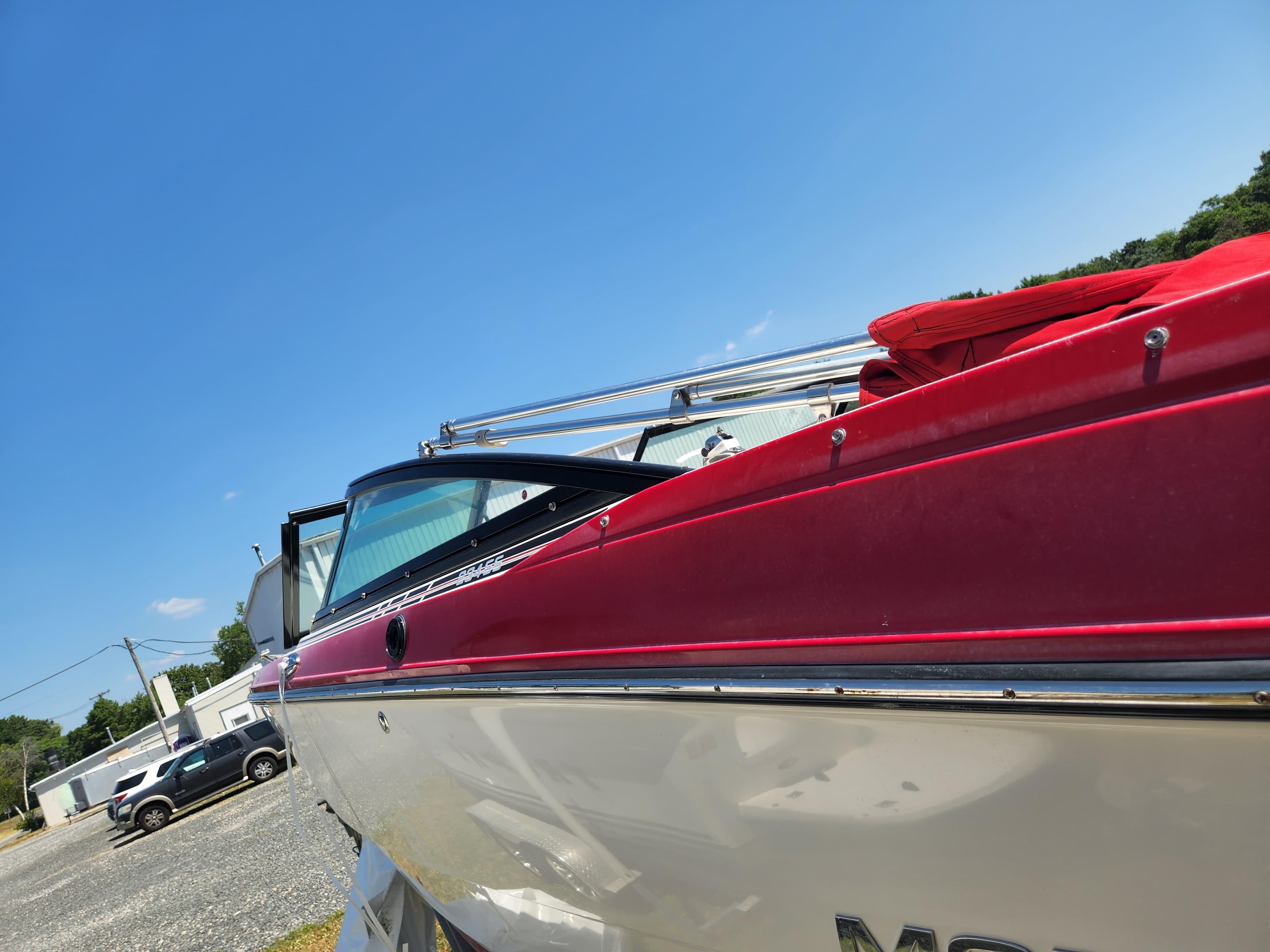 2014 Monterey 234 SS boat with red and white exterior, parked outdoors.