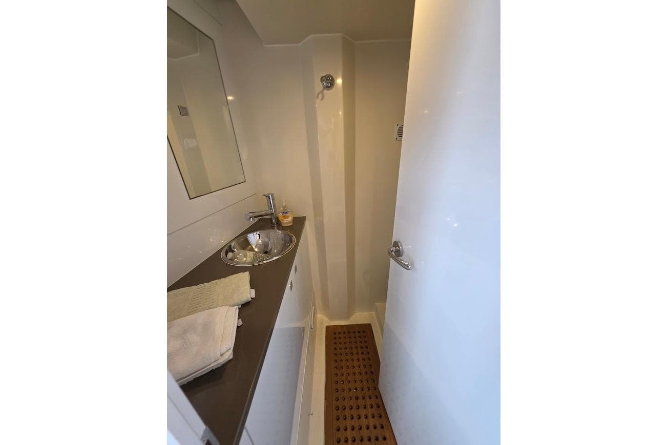 2024 Sirena 58 Flybridge MY bathroom with sink, mirror, and shower area.