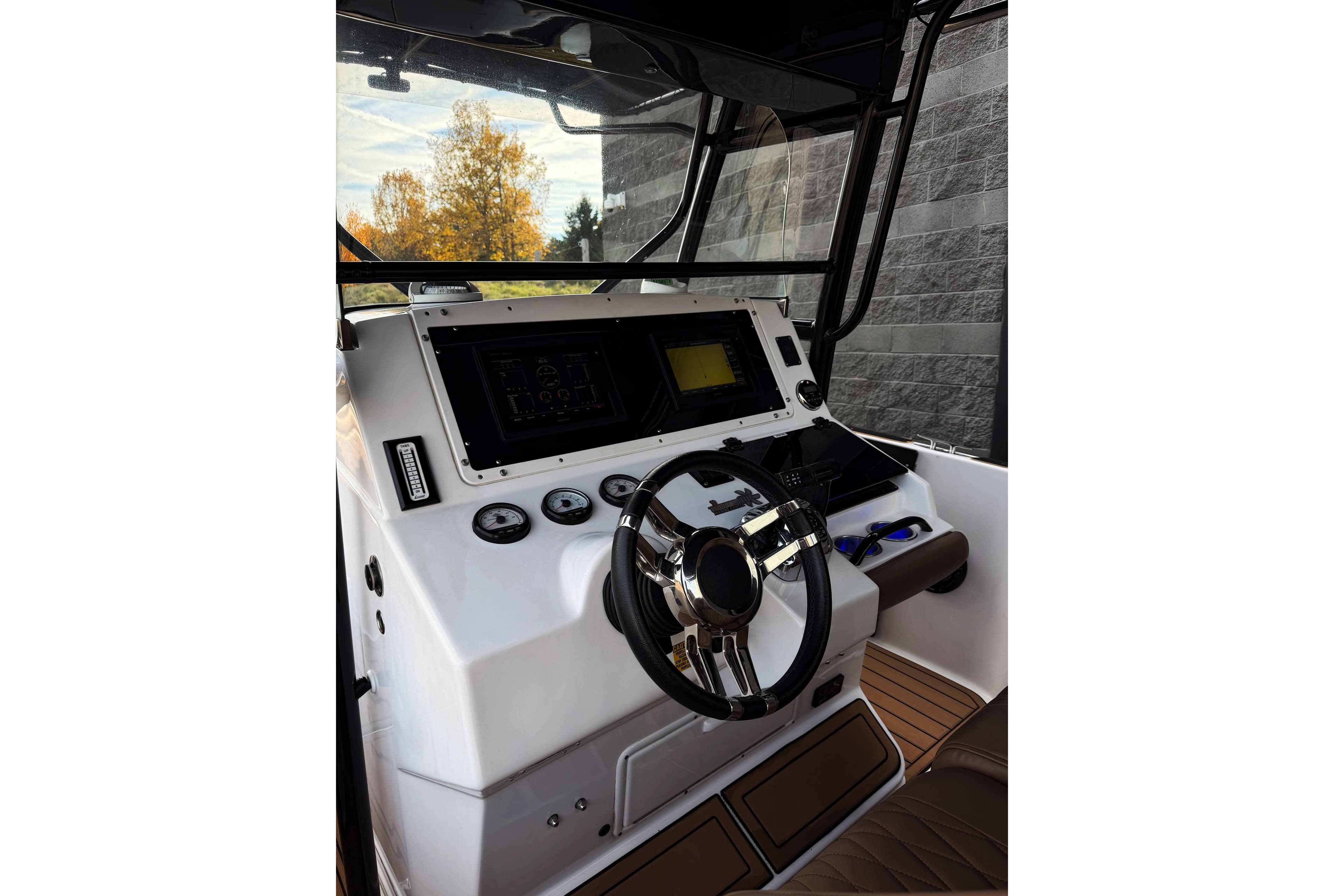 2006 Donzi 35 ZF Cuddy boat helm with steering wheel and navigation controls.