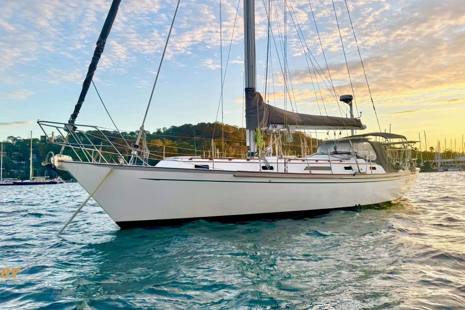 Sailboat on water at sunset, Passport 40 model, 1984, scenic background.