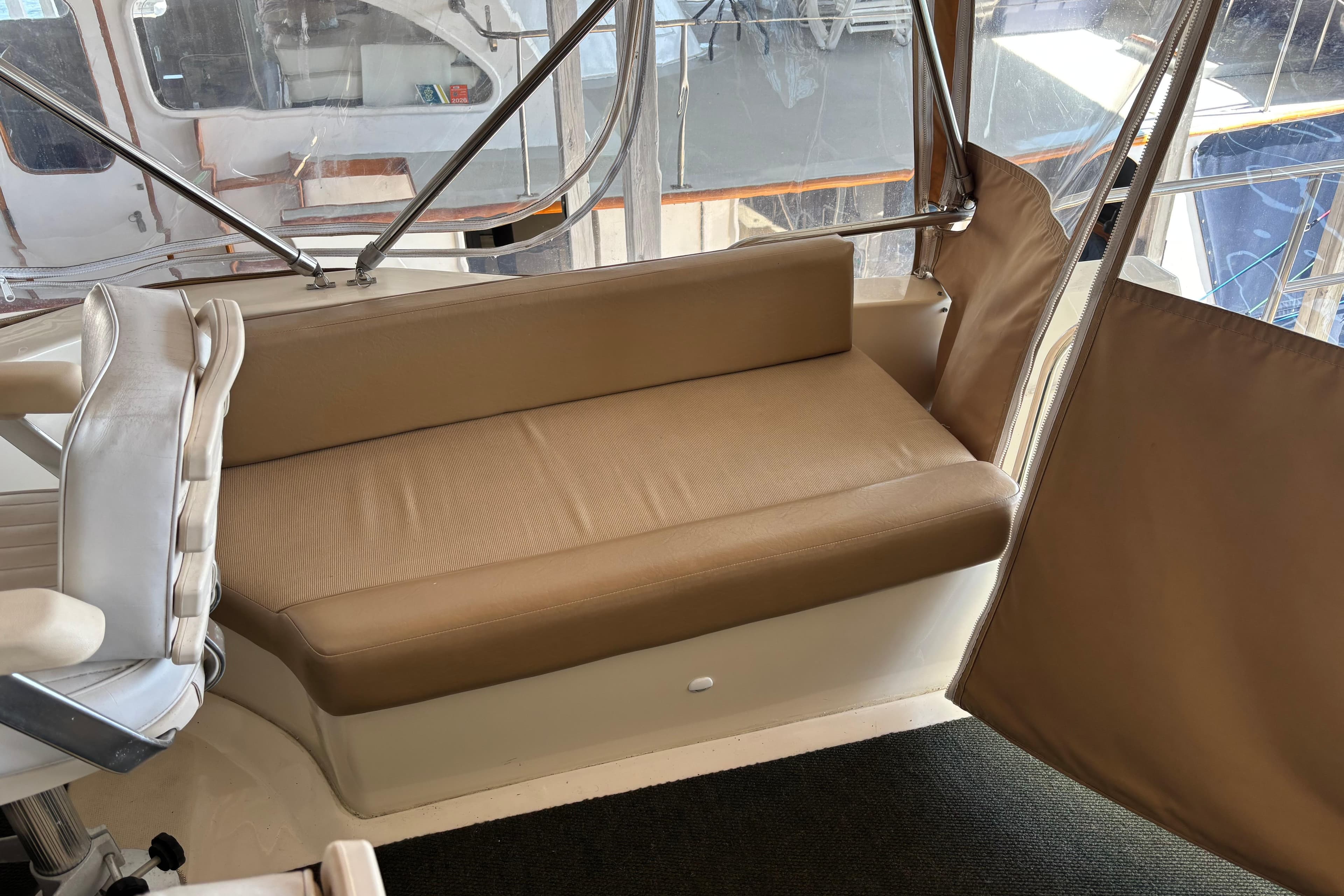 2007 Mainship 34 Trawler interior with beige seating and helm chair.