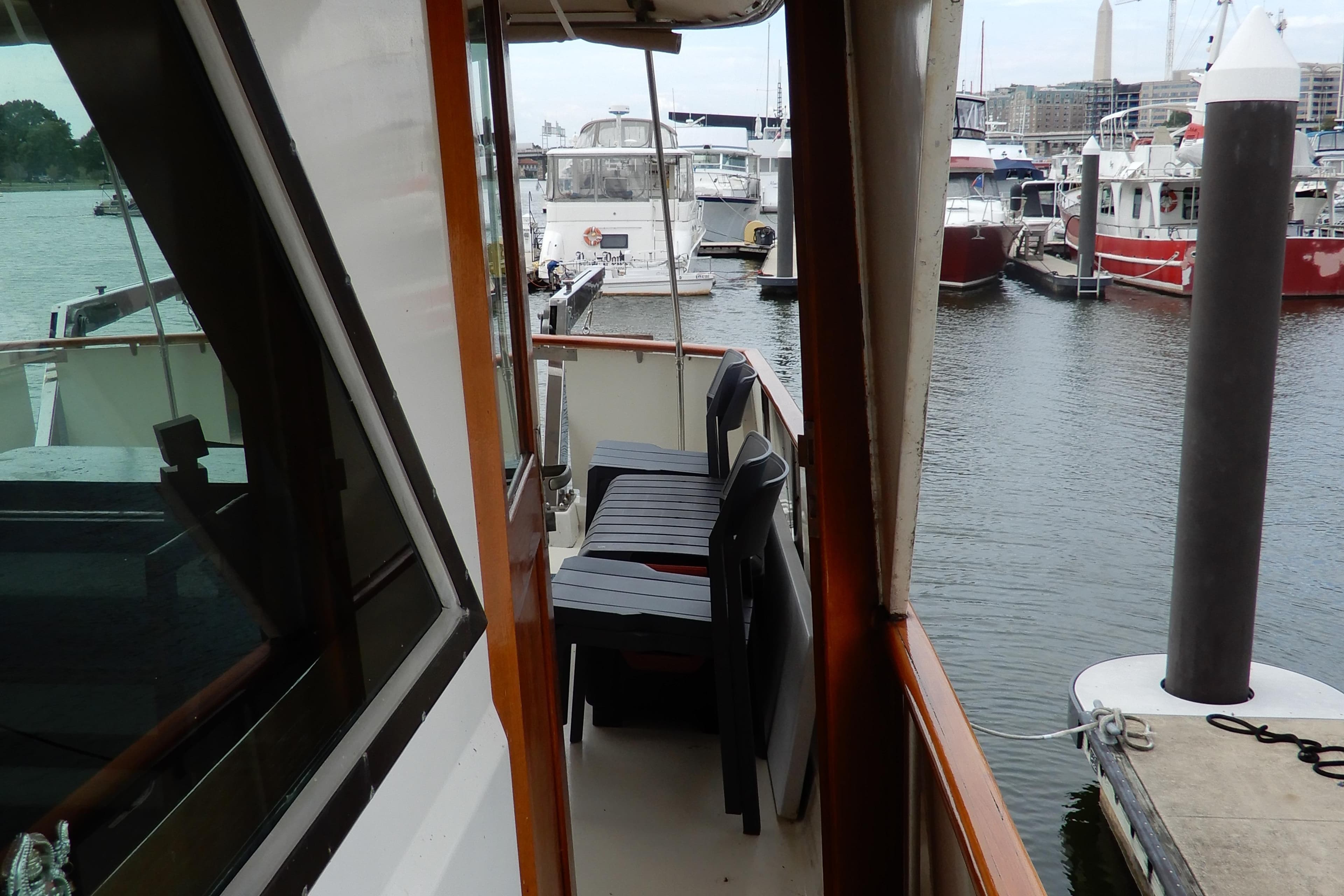 1979 Hatteras 53 Motor Yacht docked in a marina, side view with seating area.