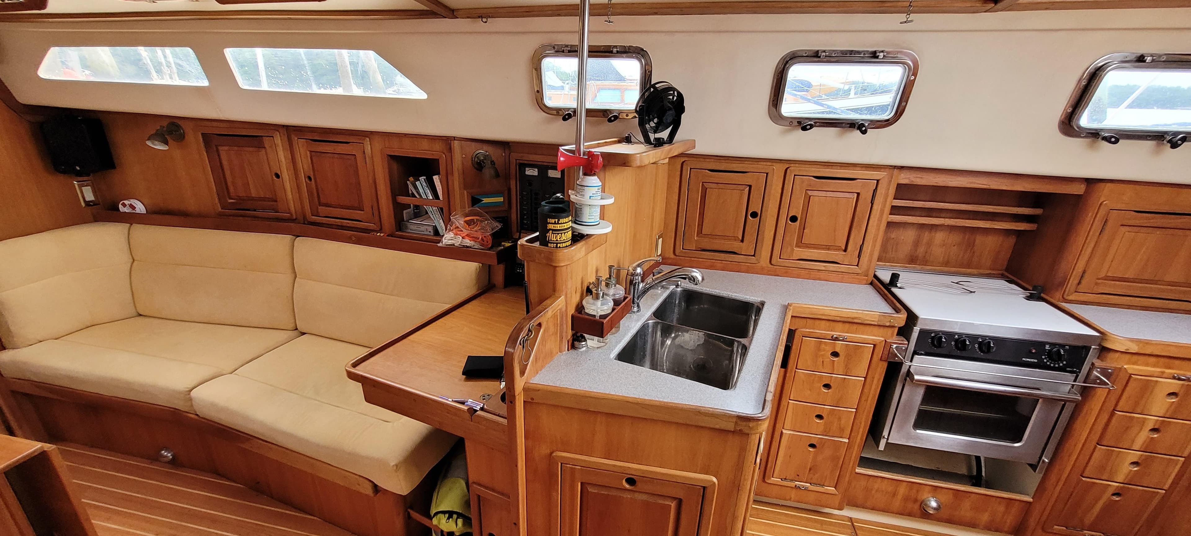 Interior of 1997 Saga 43 sailboat with wooden cabinetry and cozy seating area.