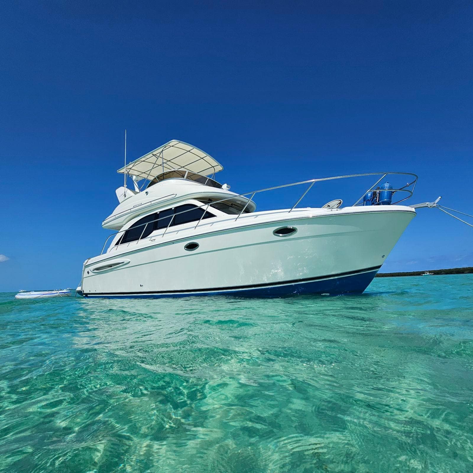 2004 Meridian Sedan Bridge 341 yacht on clear turquoise water.