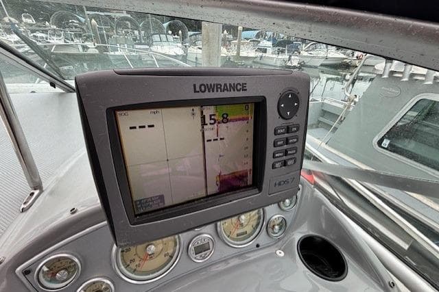 Lowrance navigation system on 2004 Maxum 2500 SE boat dashboard, marina background.