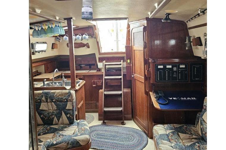 Interior of 1999 Island Packet 350 sailboat with nautical-themed decor and wooden finishes.