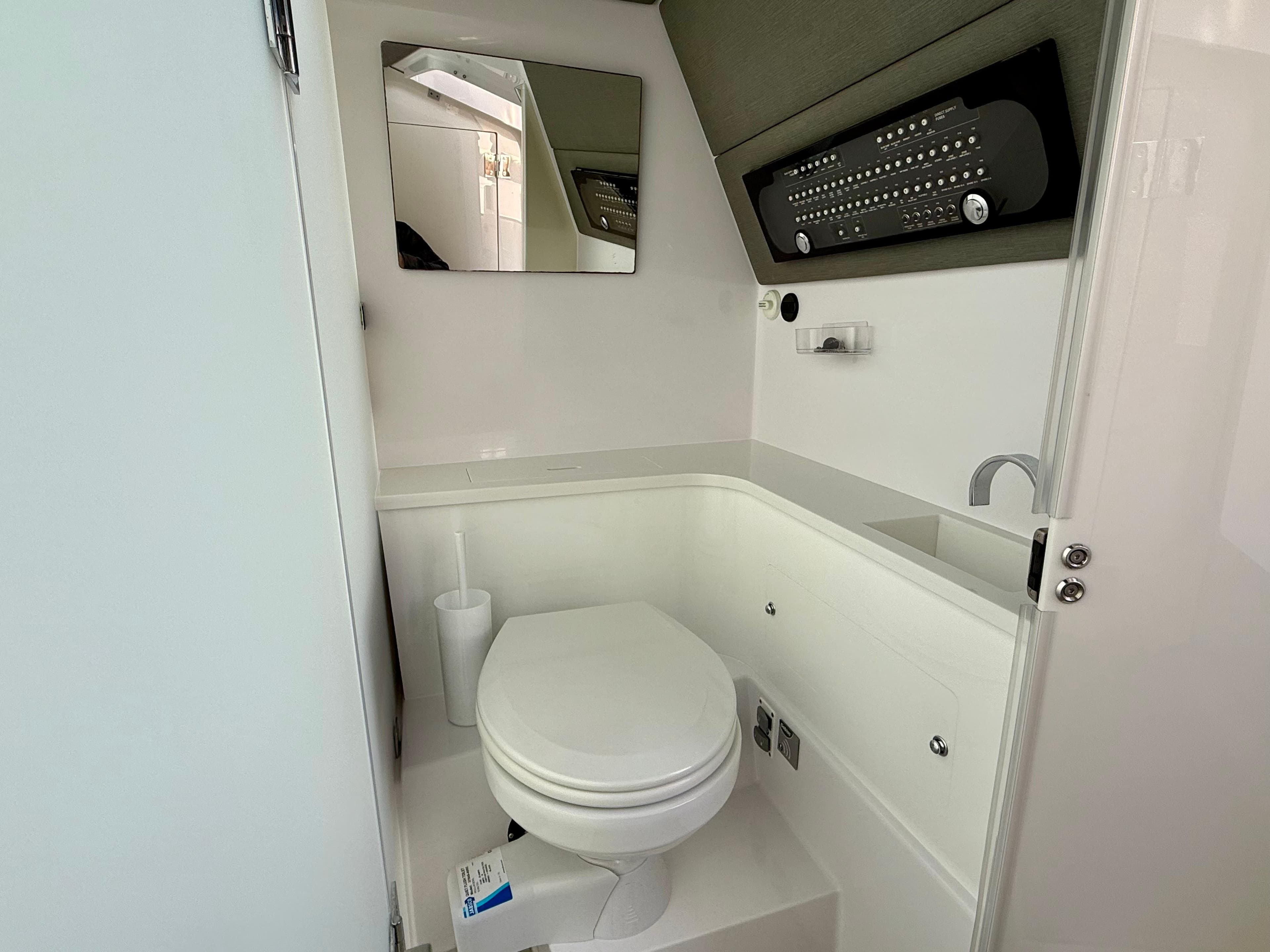 2021 Axopar 37 boat bathroom with toilet, mirror, and modern fixtures.