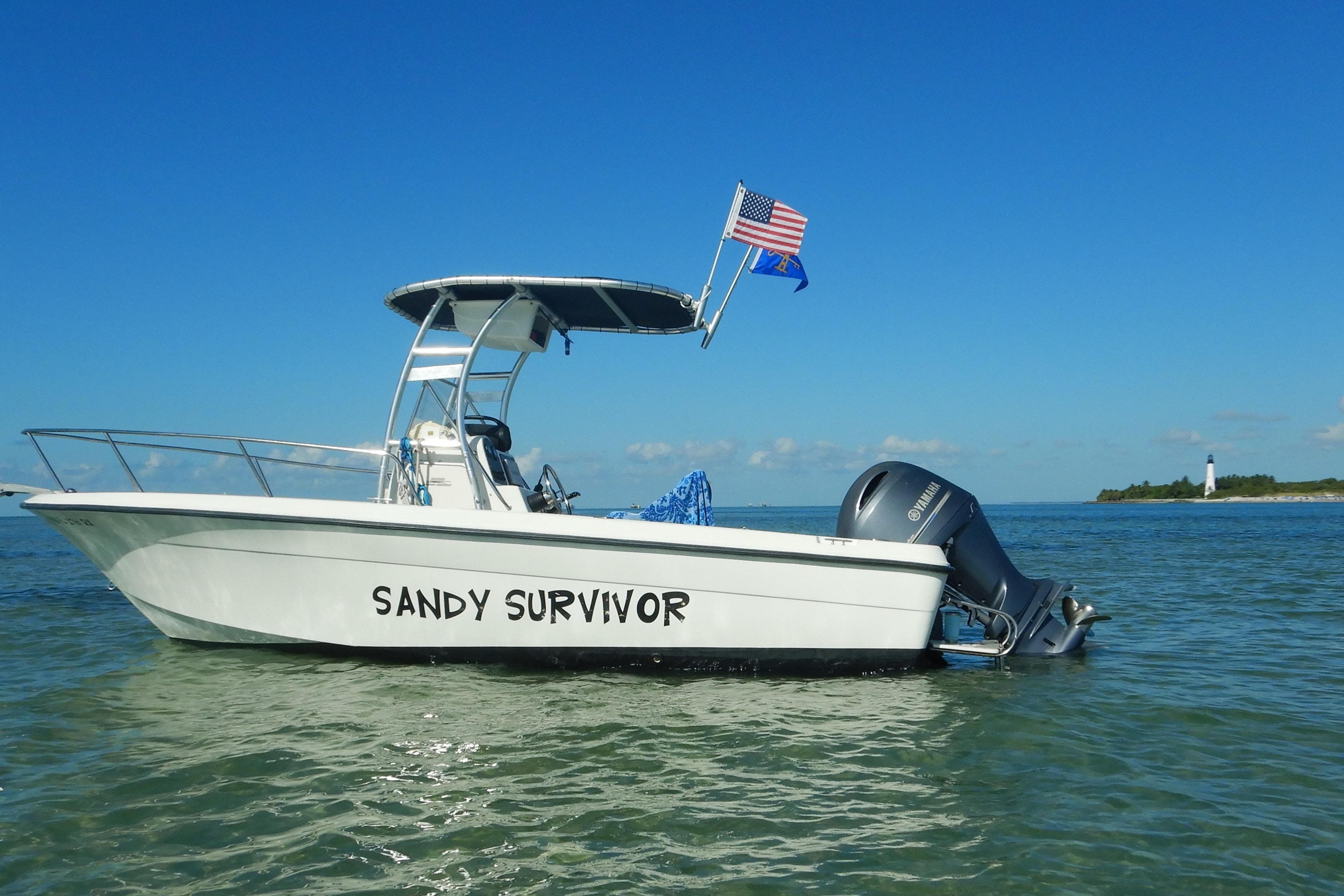 2004 Hydra-Sports 212 CC boat named "Sandy Survivor" on water with lighthouse in background.