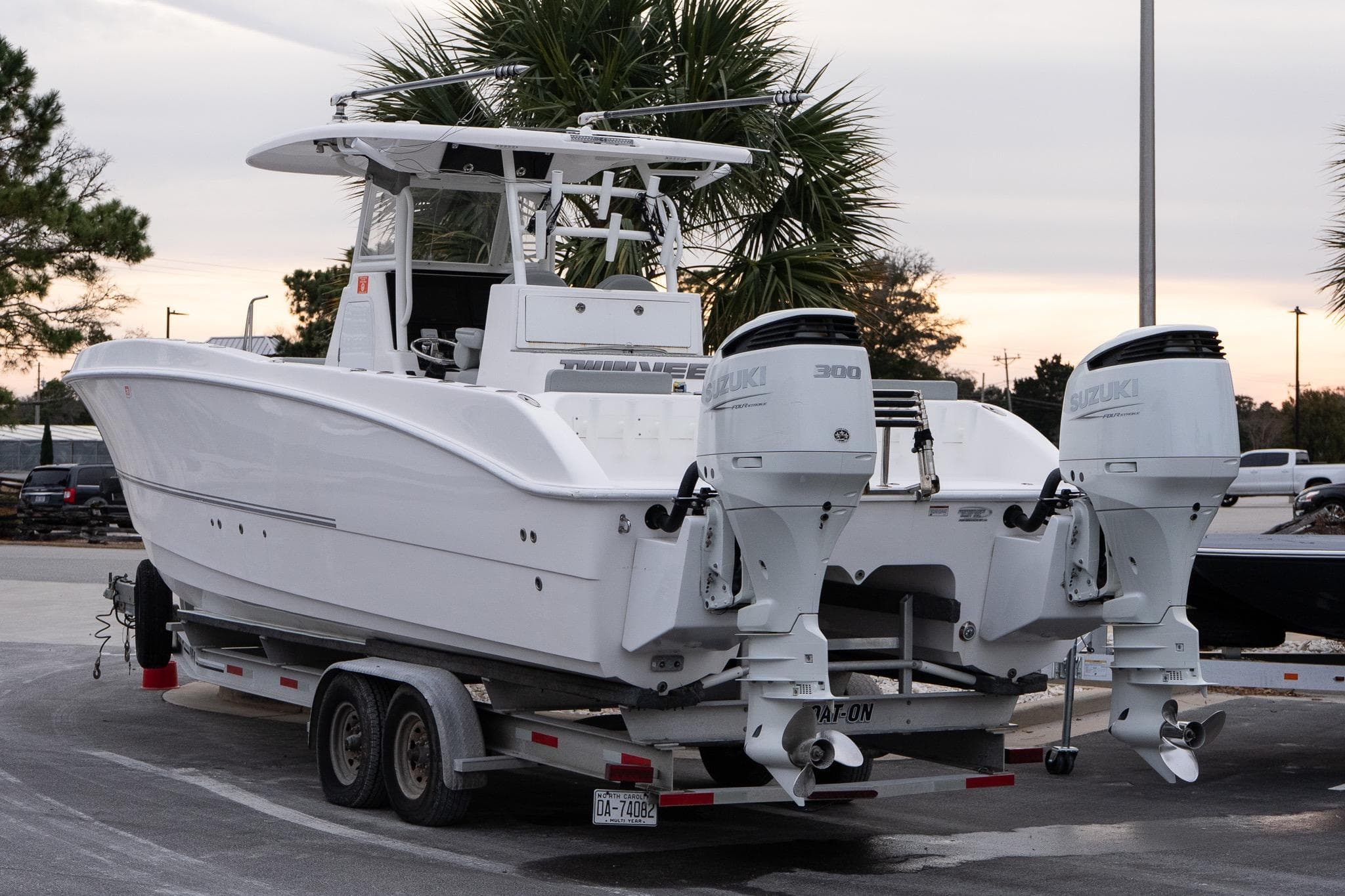 2023 Twin Vee 280 GFX CC boat on trailer with dual Suzuki engines.