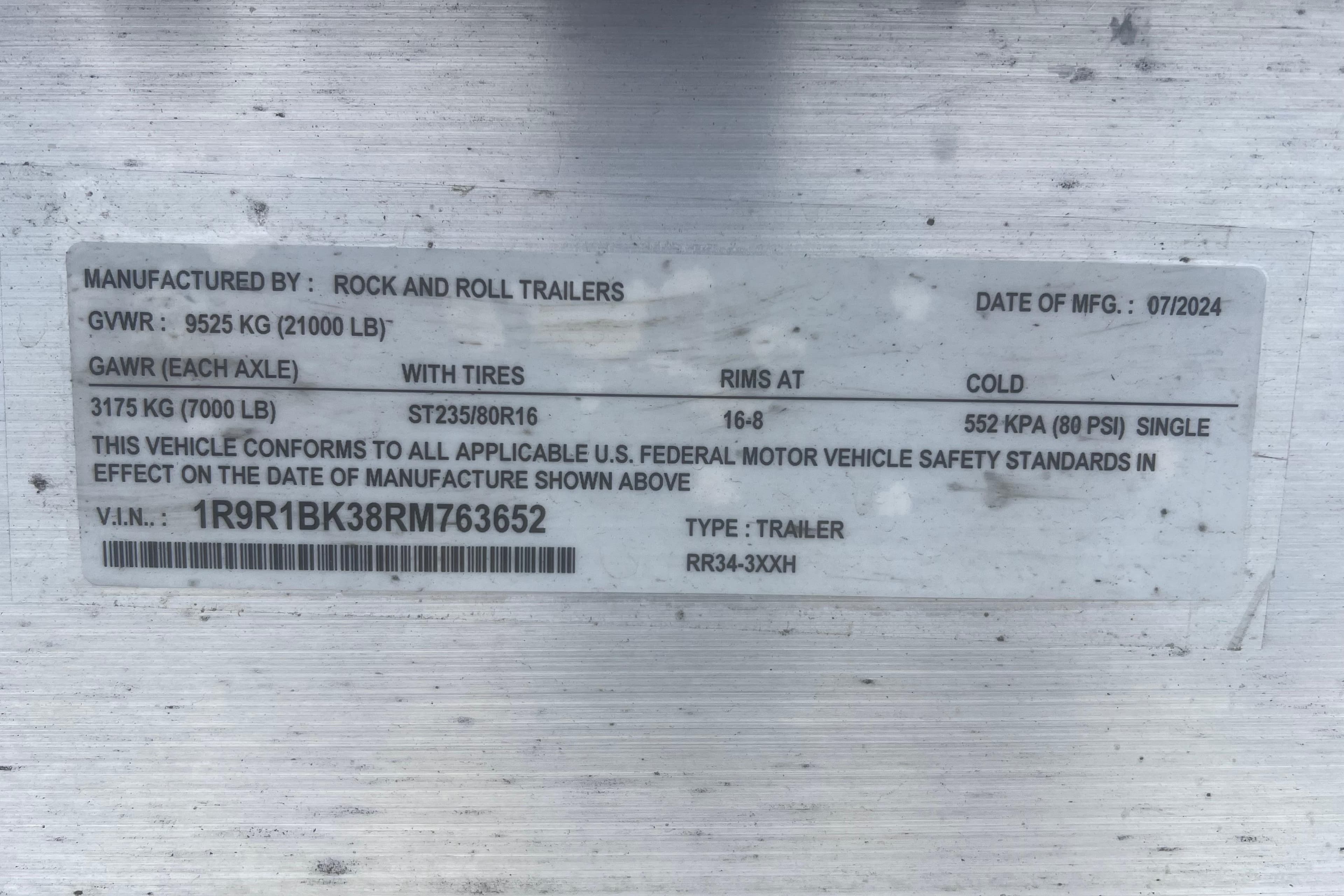 Label on a trailer showing specifications and compliance details, manufactured by Rock and Roll Trailers.