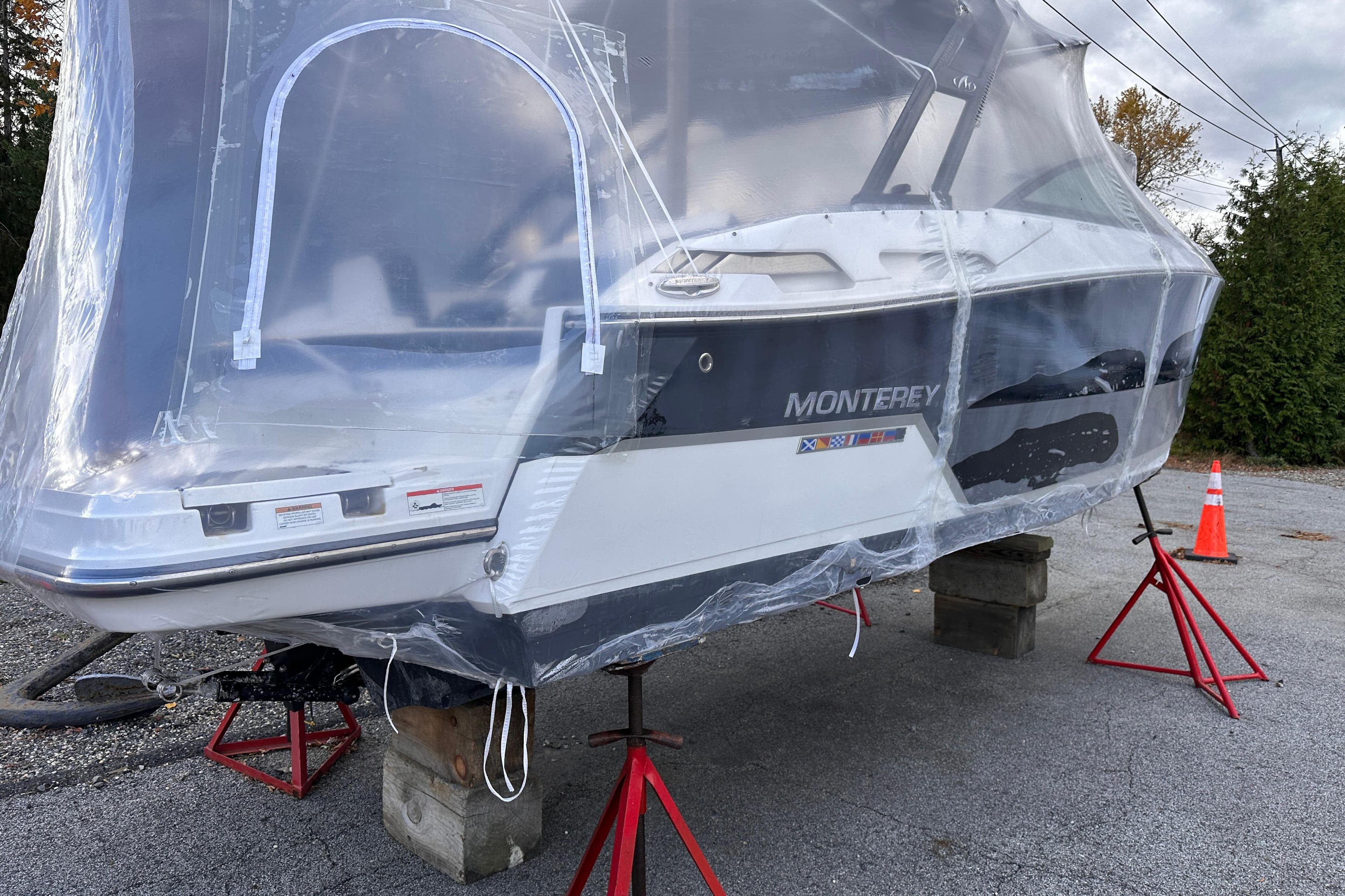 2018 Monterey 258SS Super Sport boat covered in protective wrap, elevated on stands.