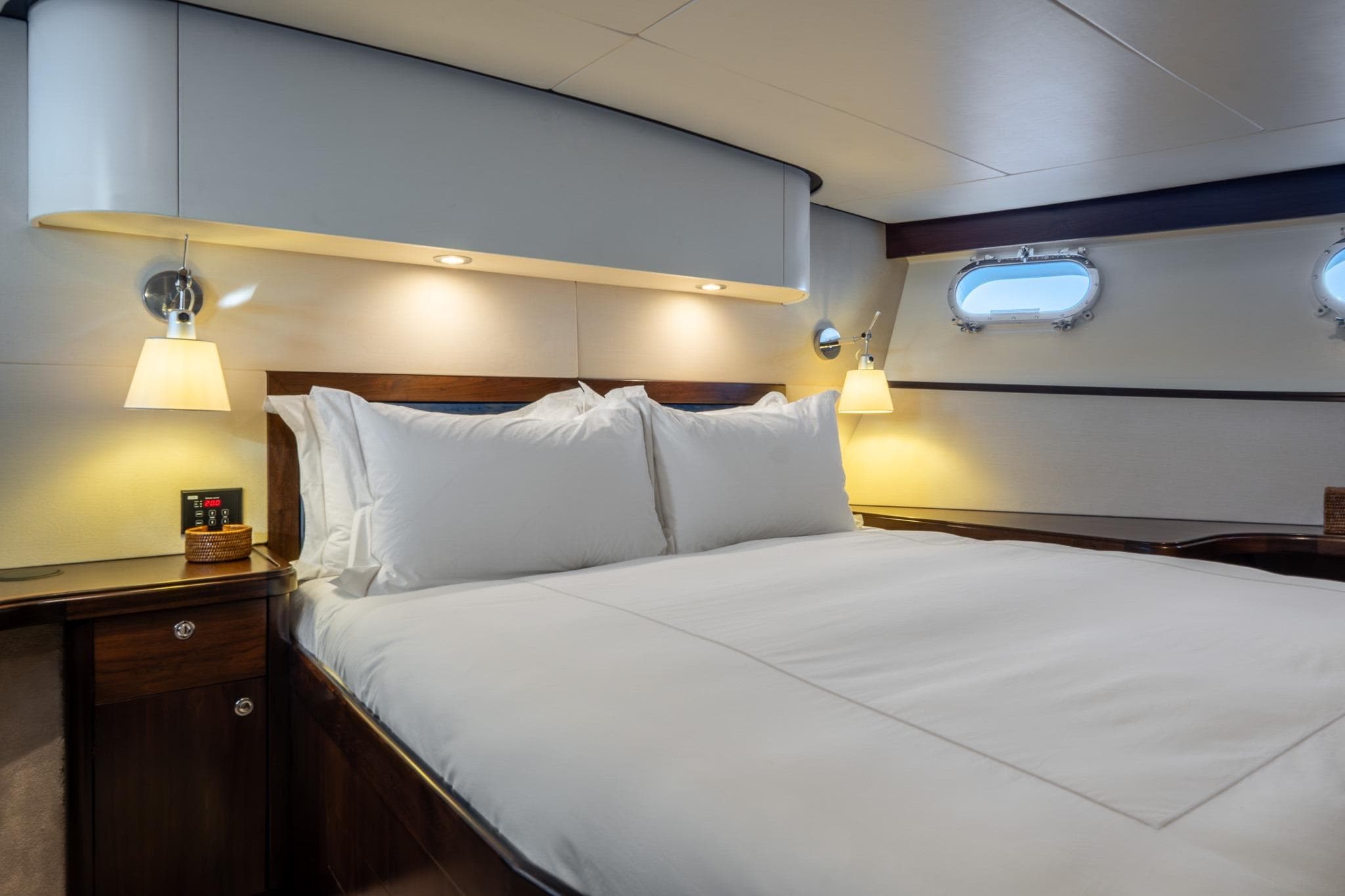 Luxurious cabin interior of 1969 Feadship 25.8m yacht with elegant bedding and ambient lighting.