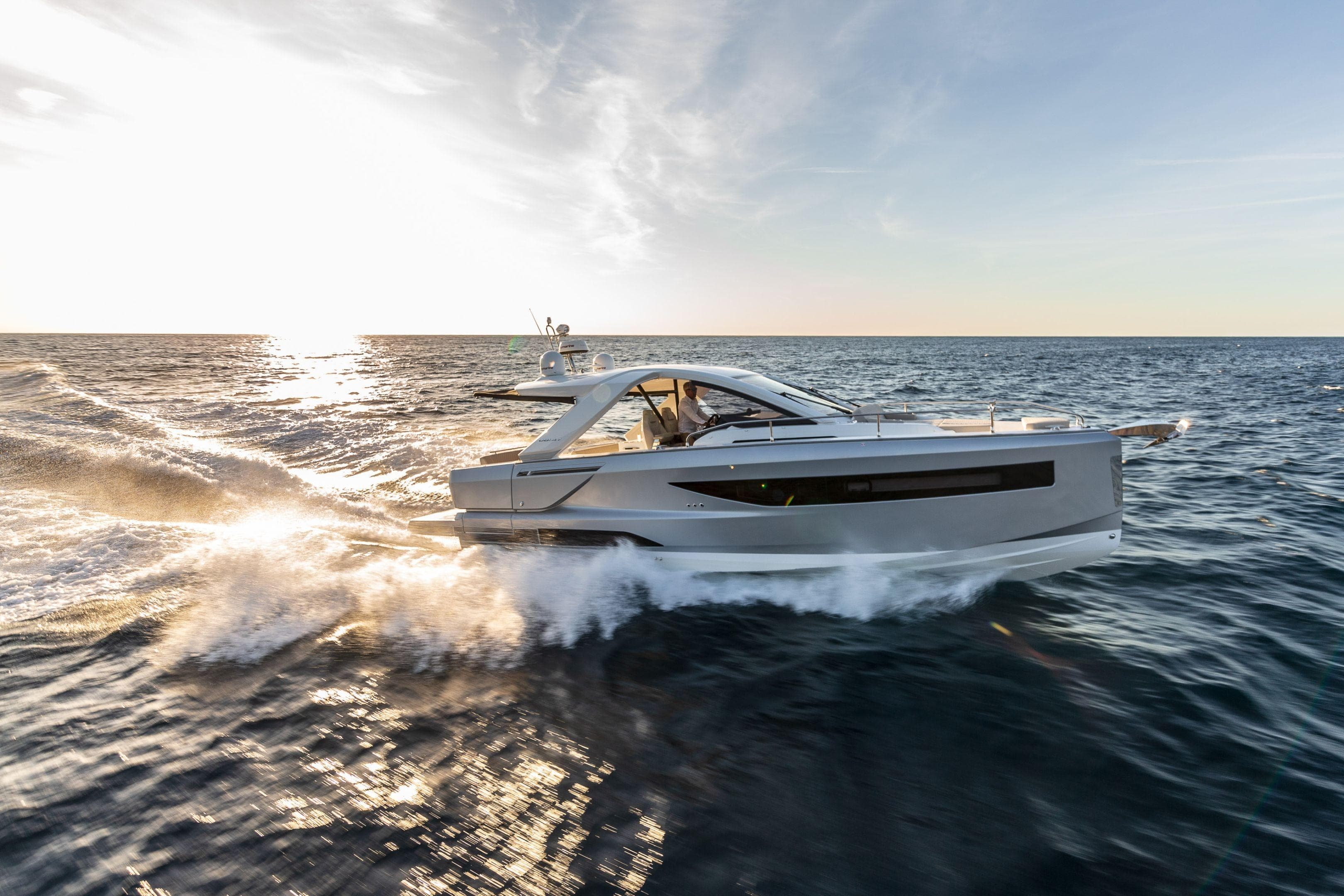 2025 Jeanneau DB/37 IB yacht cruising on open sea at sunset.