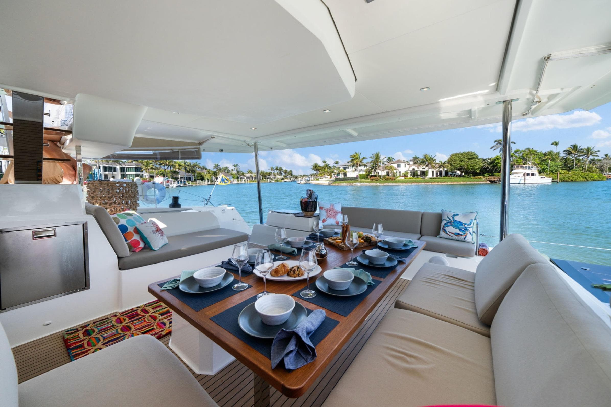 Luxurious 2024 Fountaine Pajot Aura 51 Catamaran with elegant dining setup and scenic waterfront view.