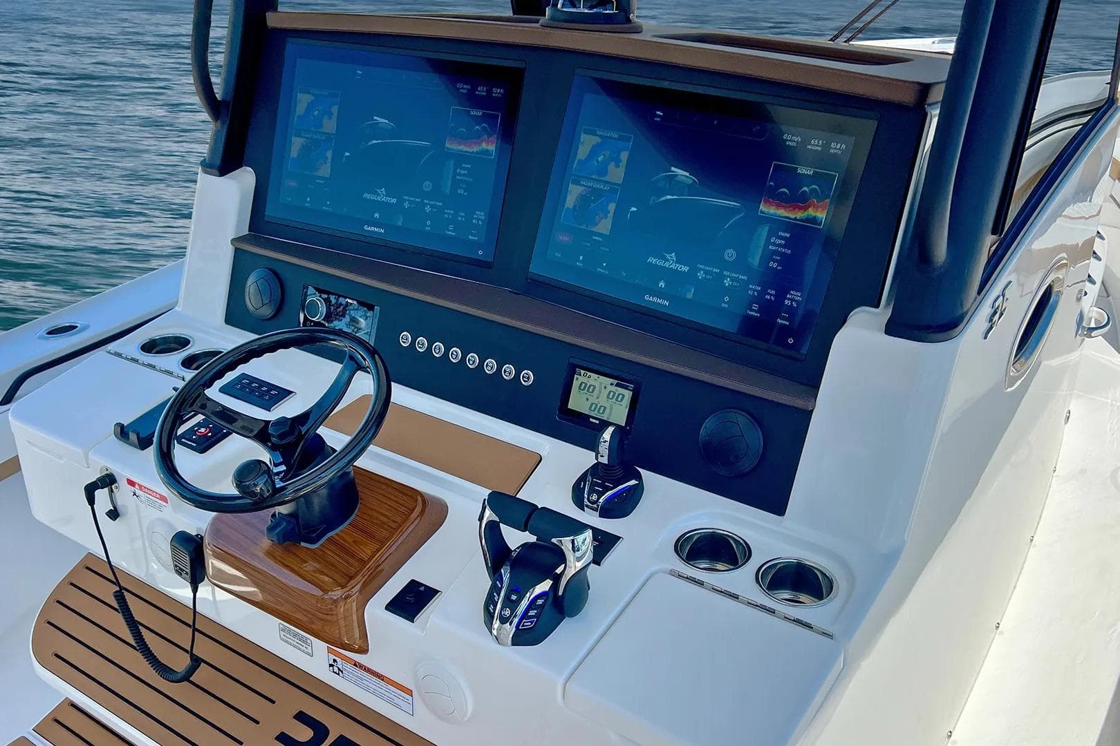 Manufacturer Provided Image: 2026 Regulator 35 boat dashboard with dual Garmin displays and steering wheel.
