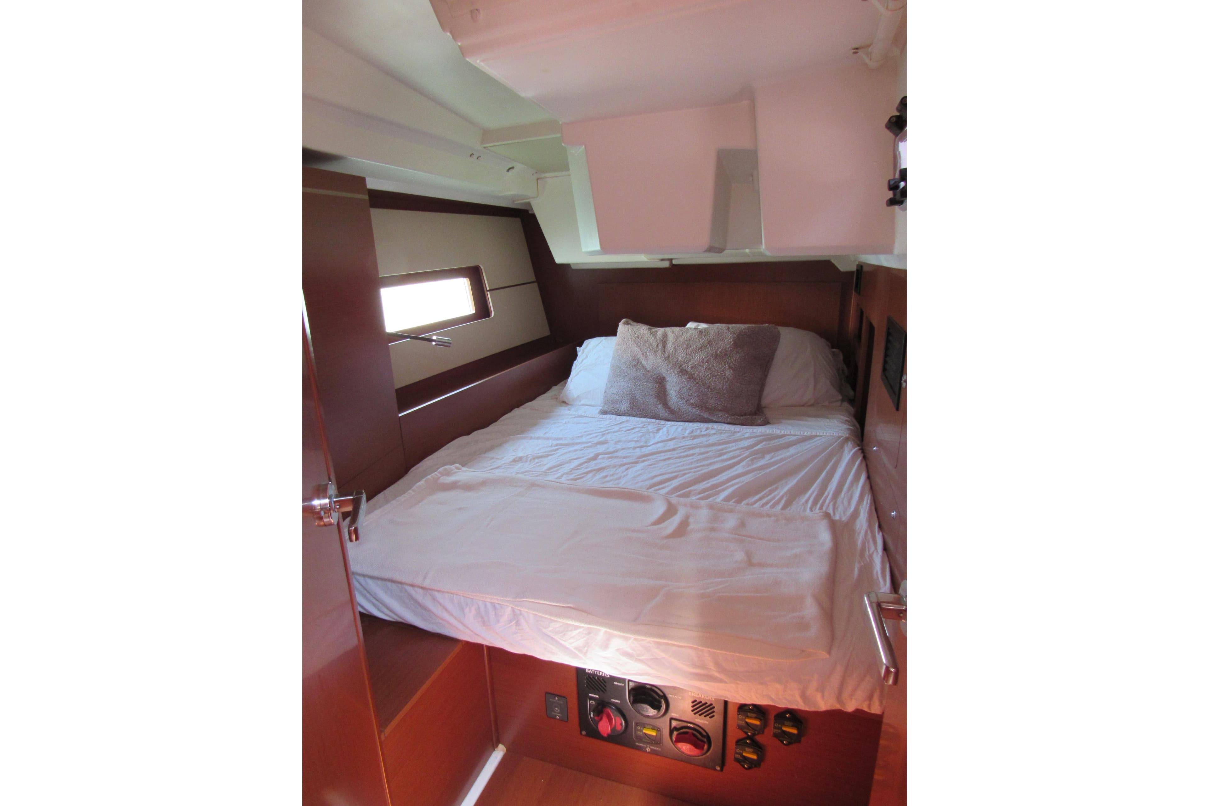 Cozy cabin interior of 2020 Beneteau Oceanis 46.1 yacht with comfortable bed and wooden finish.