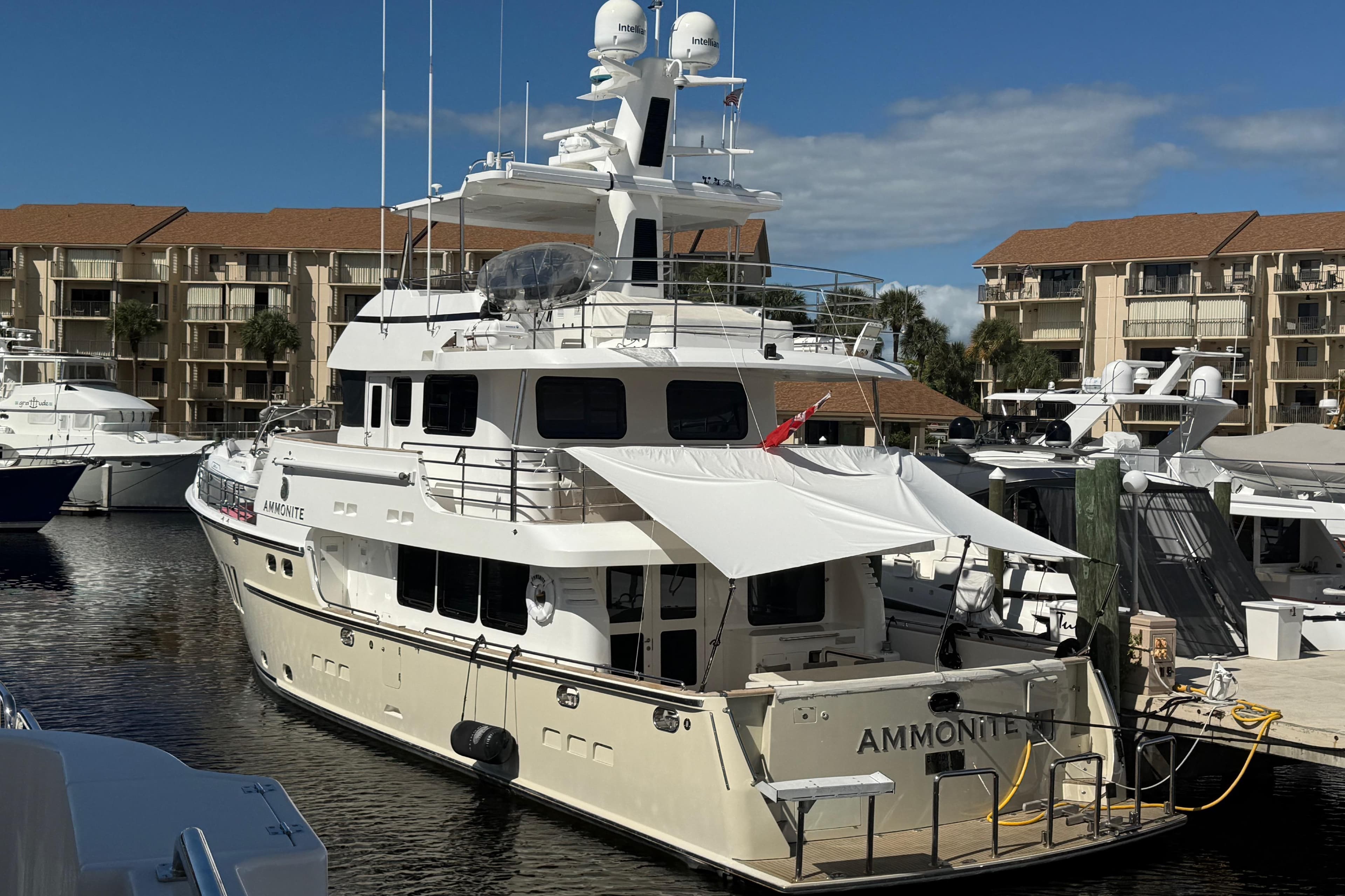 Nordhavn N78 yacht docked at marina, 2009 model, with buildings in background.