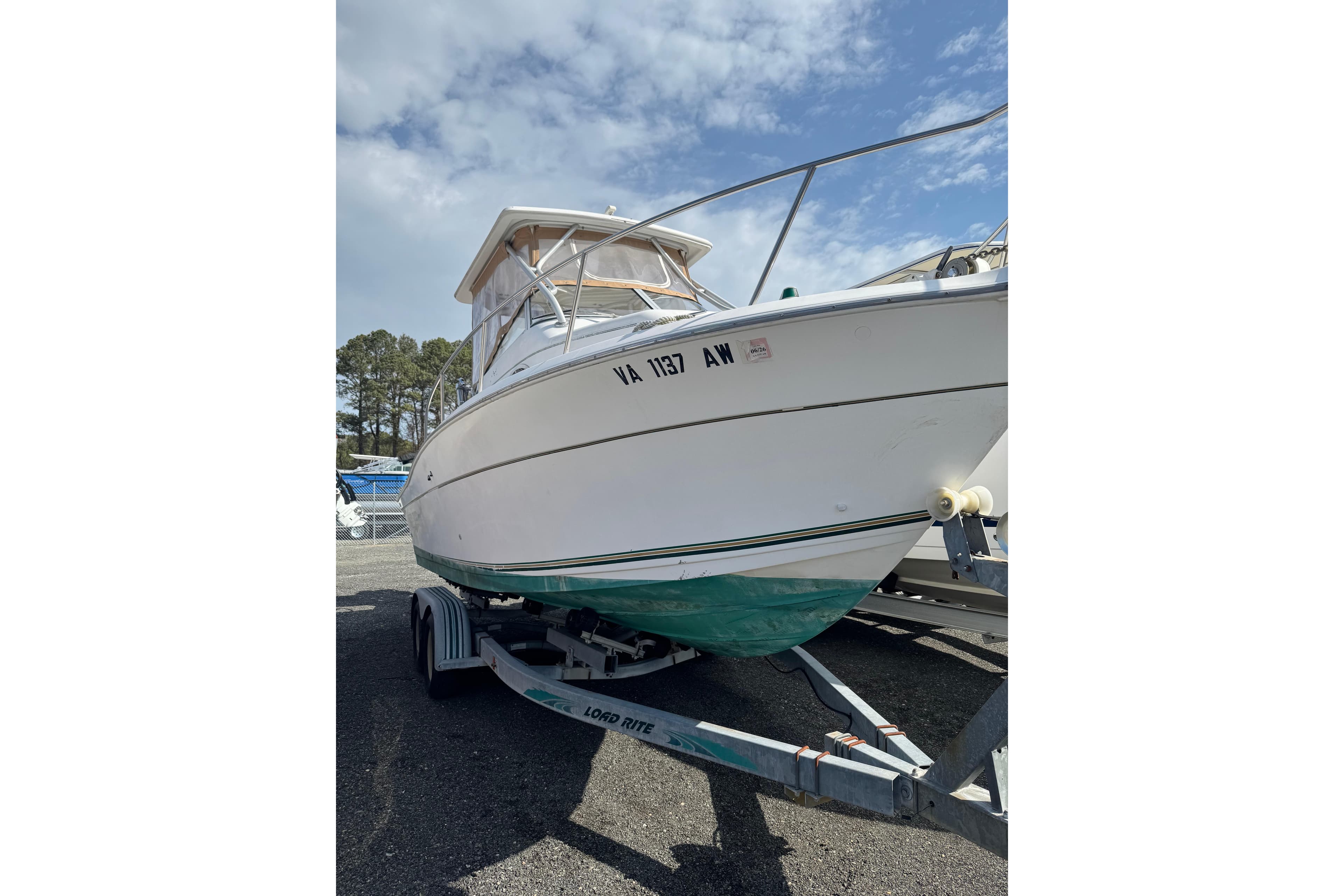 2000 Sport-Craft 241 Walk Around boat on trailer under a partly cloudy sky.