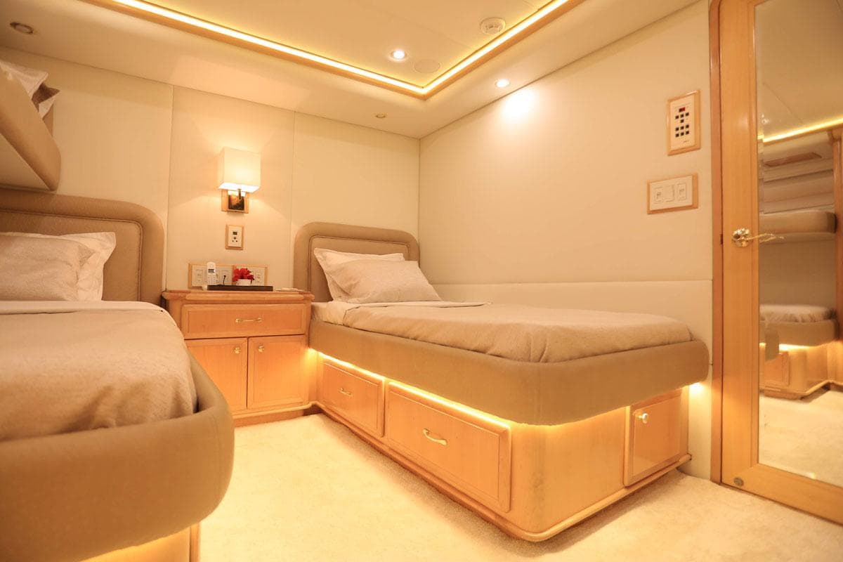Luxurious 2004 Westport Custom yacht cabin with twin beds and warm ambient lighting.