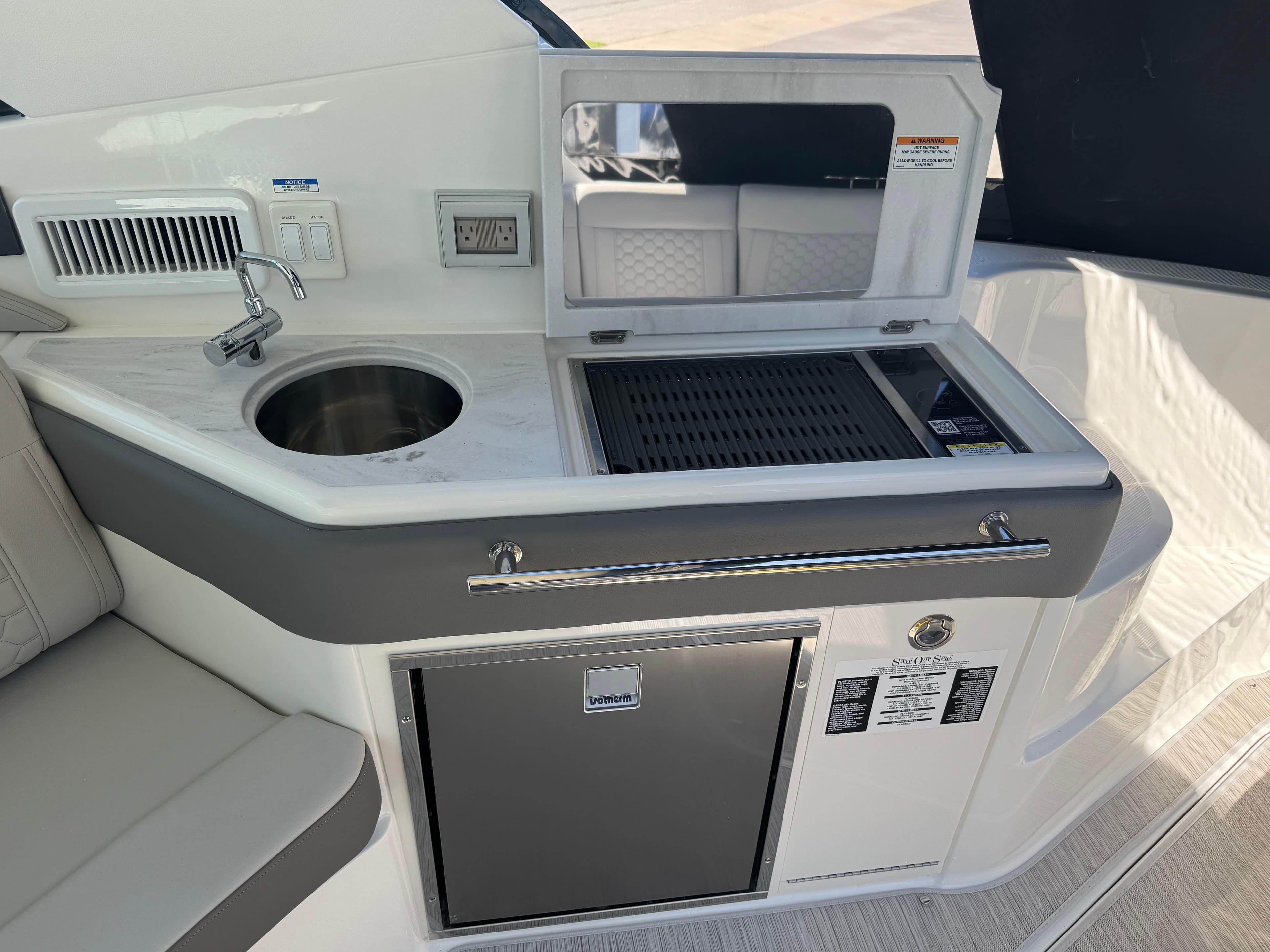 2025 Sea Ray Sundancer 320 Coupe kitchenette with sink, grill, and mini fridge.