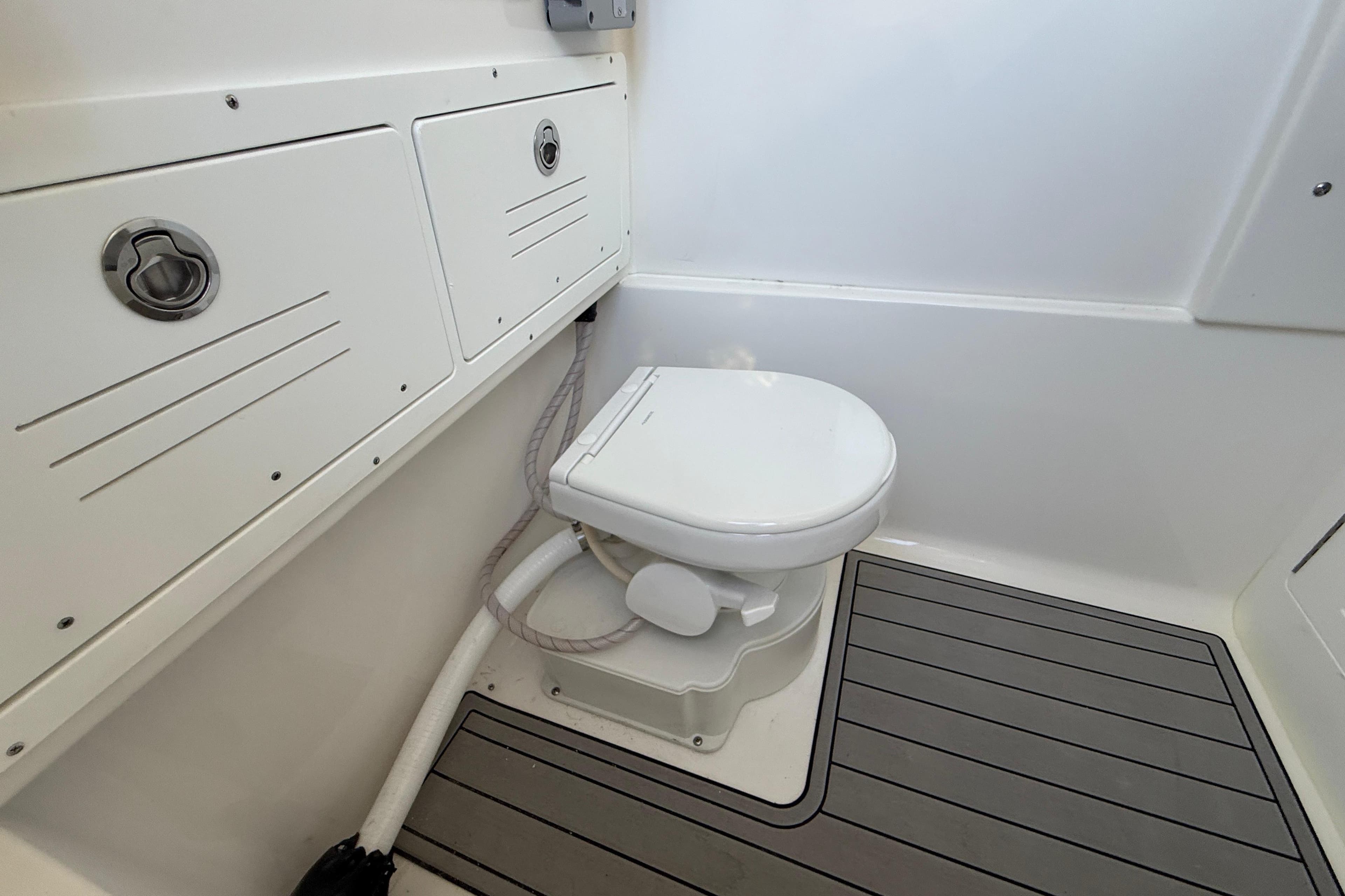 2026 Sea Pro 292 DLX boat bathroom with toilet and storage compartments.