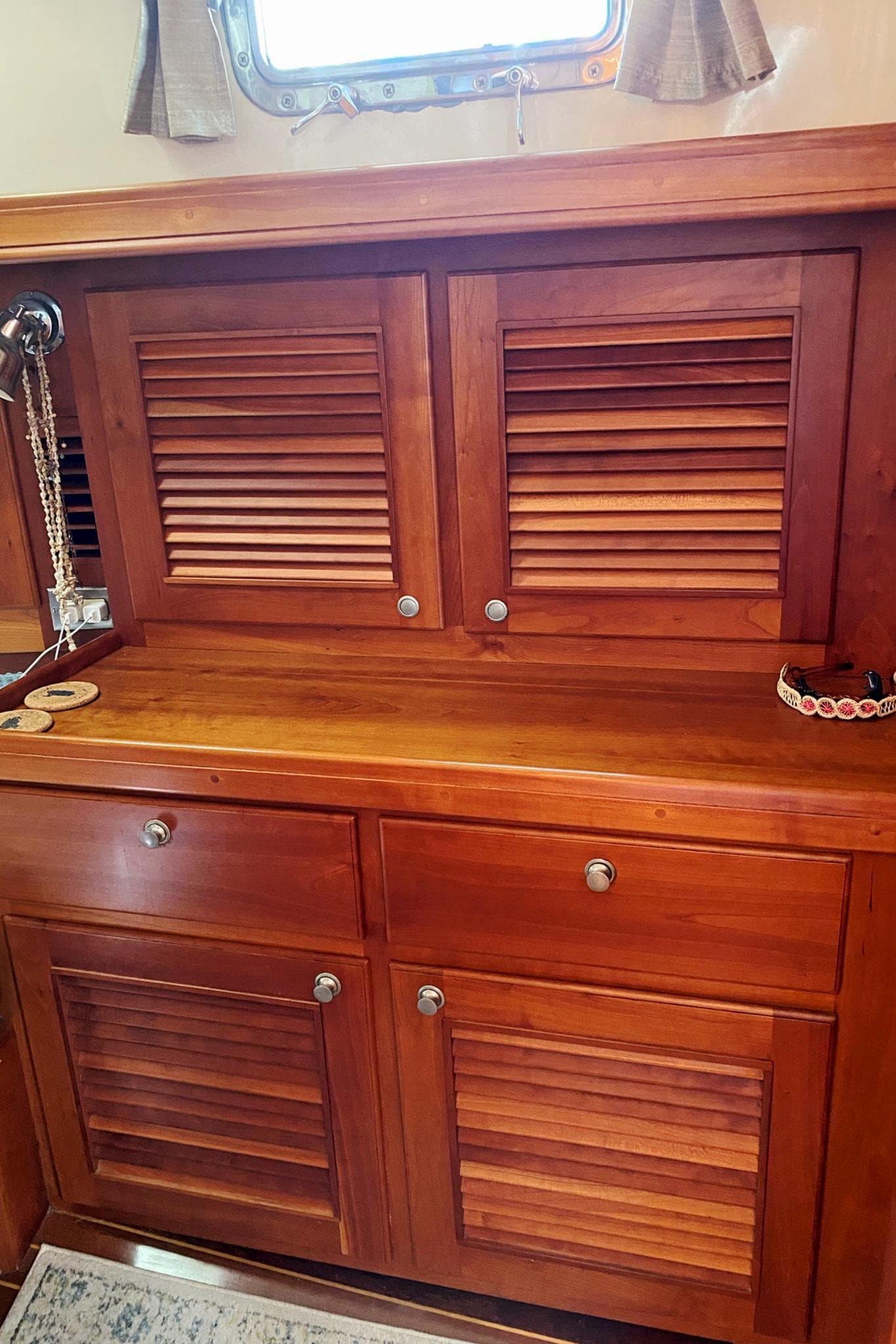 Wooden cabinetry inside a 2002 Gozzard 41 yacht, featuring louvered doors and a polished finish.