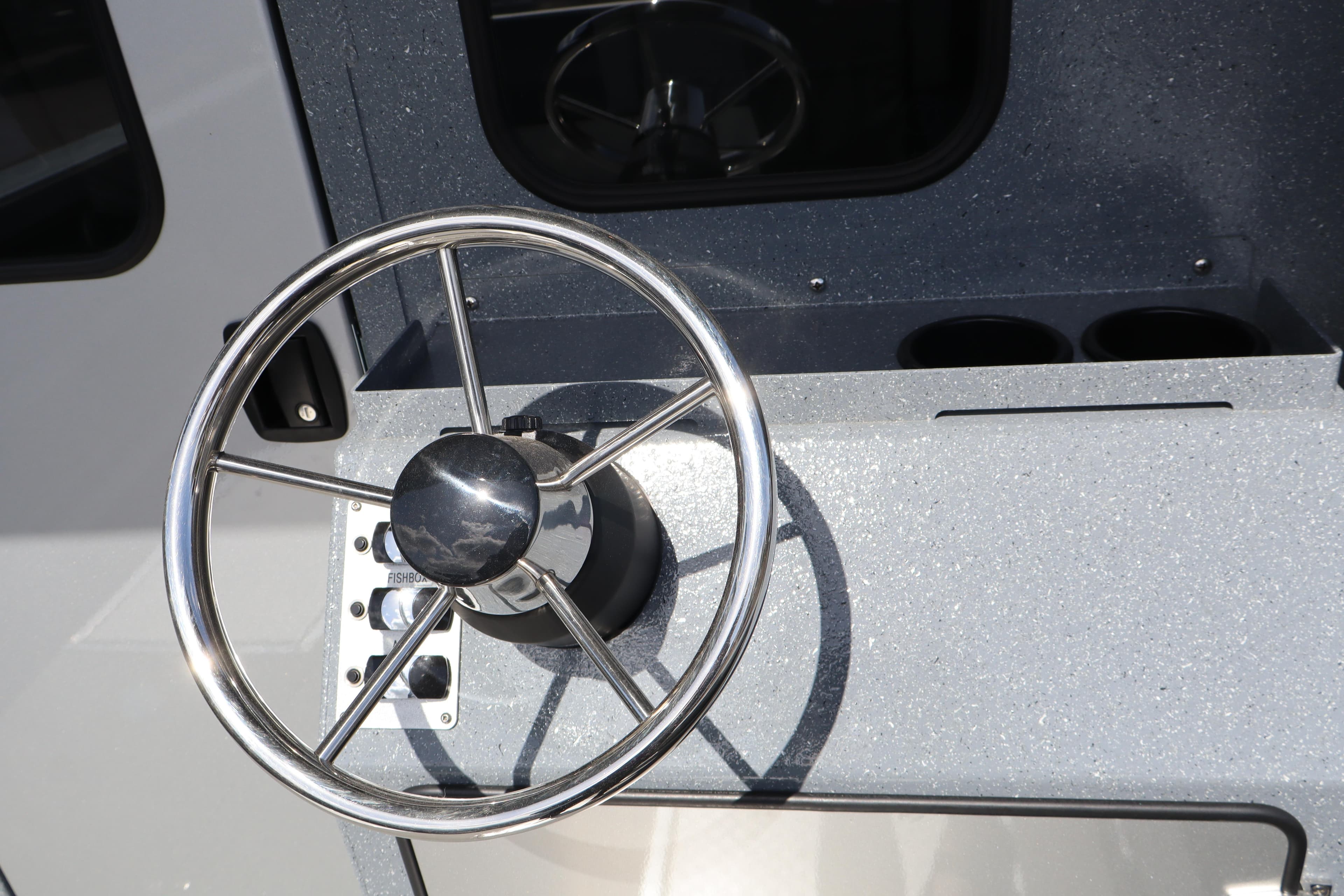 Steering wheel of 2026 KingFisher 2825 Coastal Express boat, featuring sleek metallic design.
