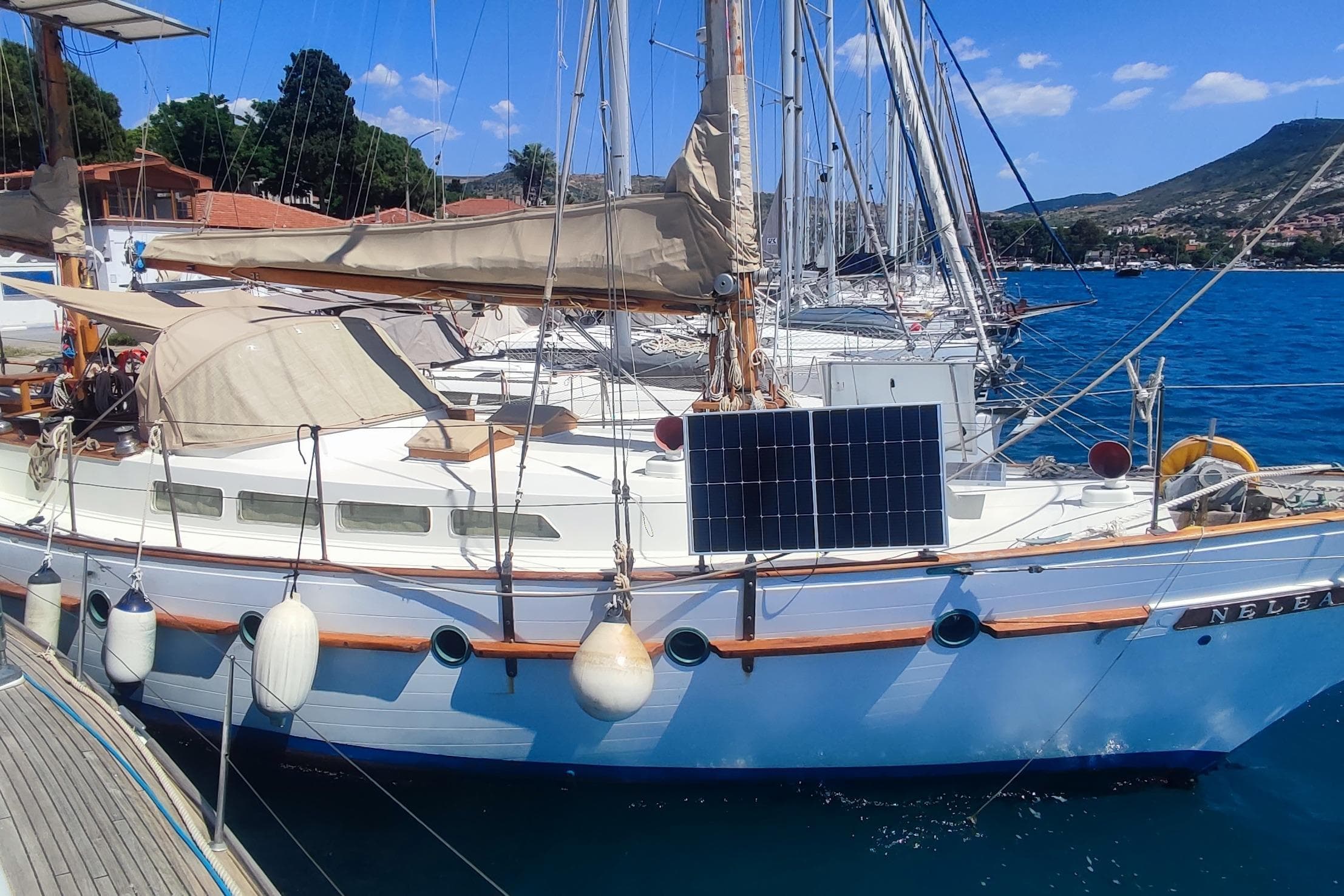 Vintage 1980 Formosa 51 sailboat docked, featuring solar panels and classic design.