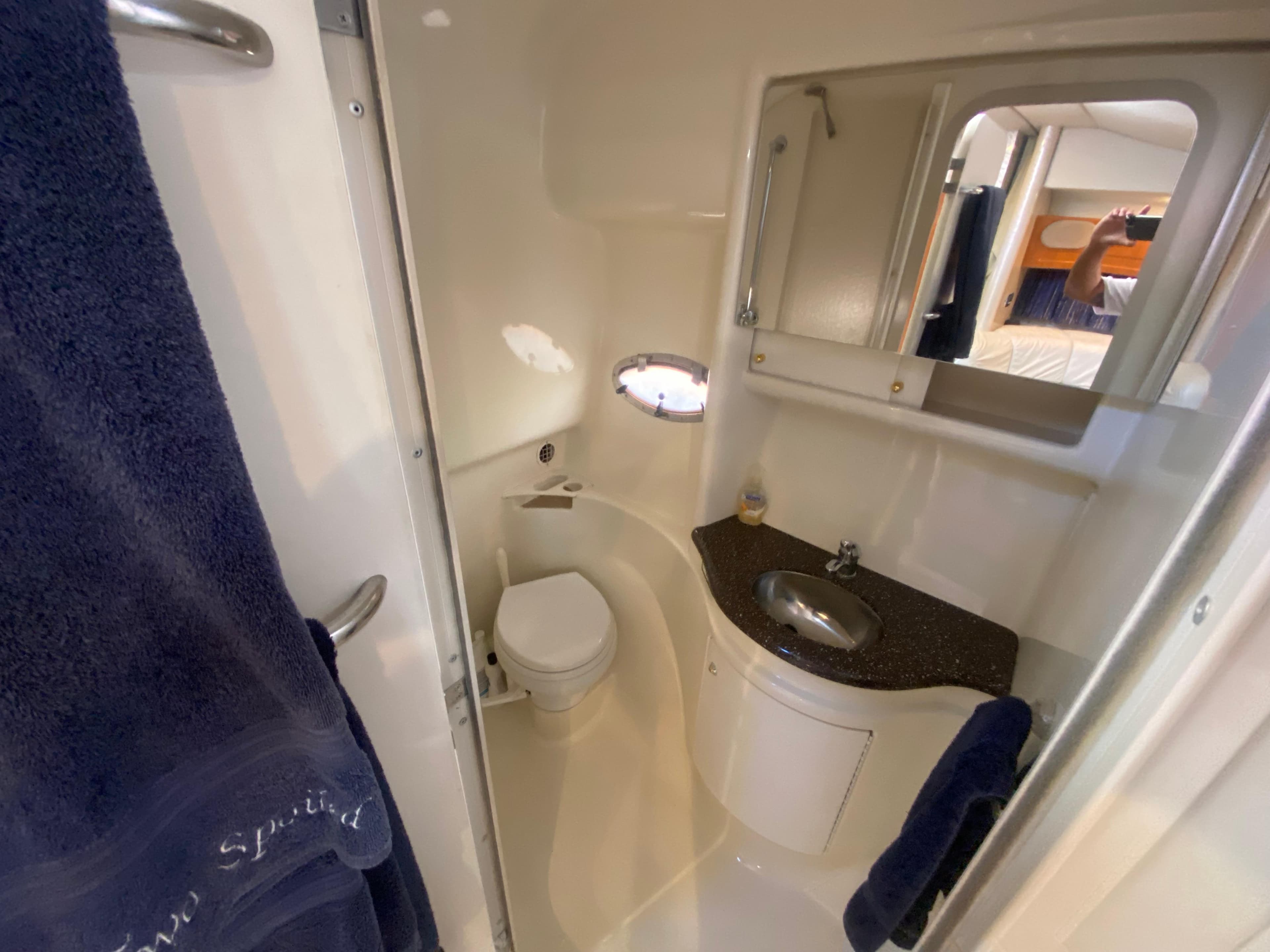 Compact bathroom in 2003 Formula 37PC yacht with sink, toilet, and mirror.