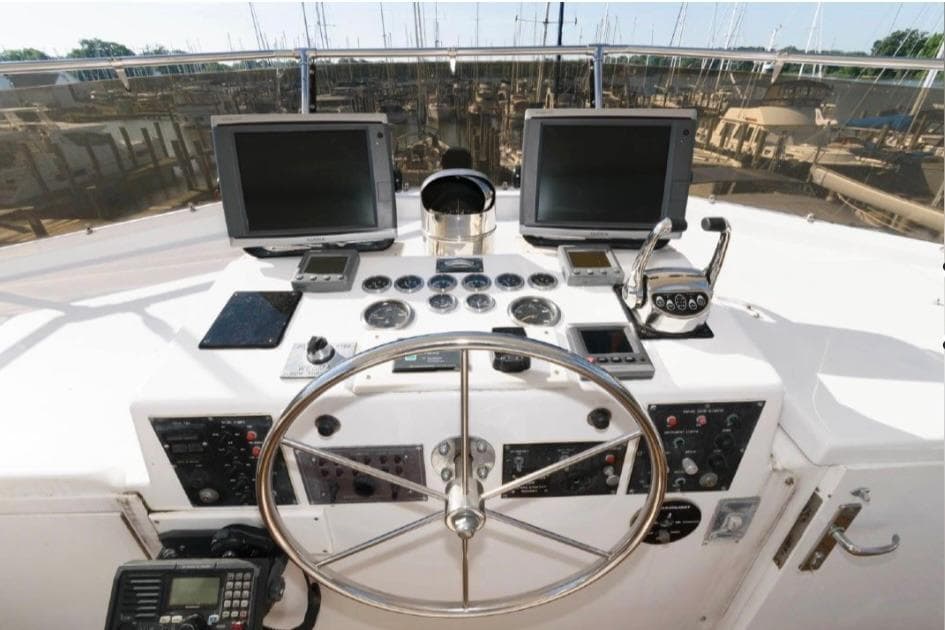 Helm of 1988 Hatteras 54 Motor Yacht with navigation equipment and steering wheel.