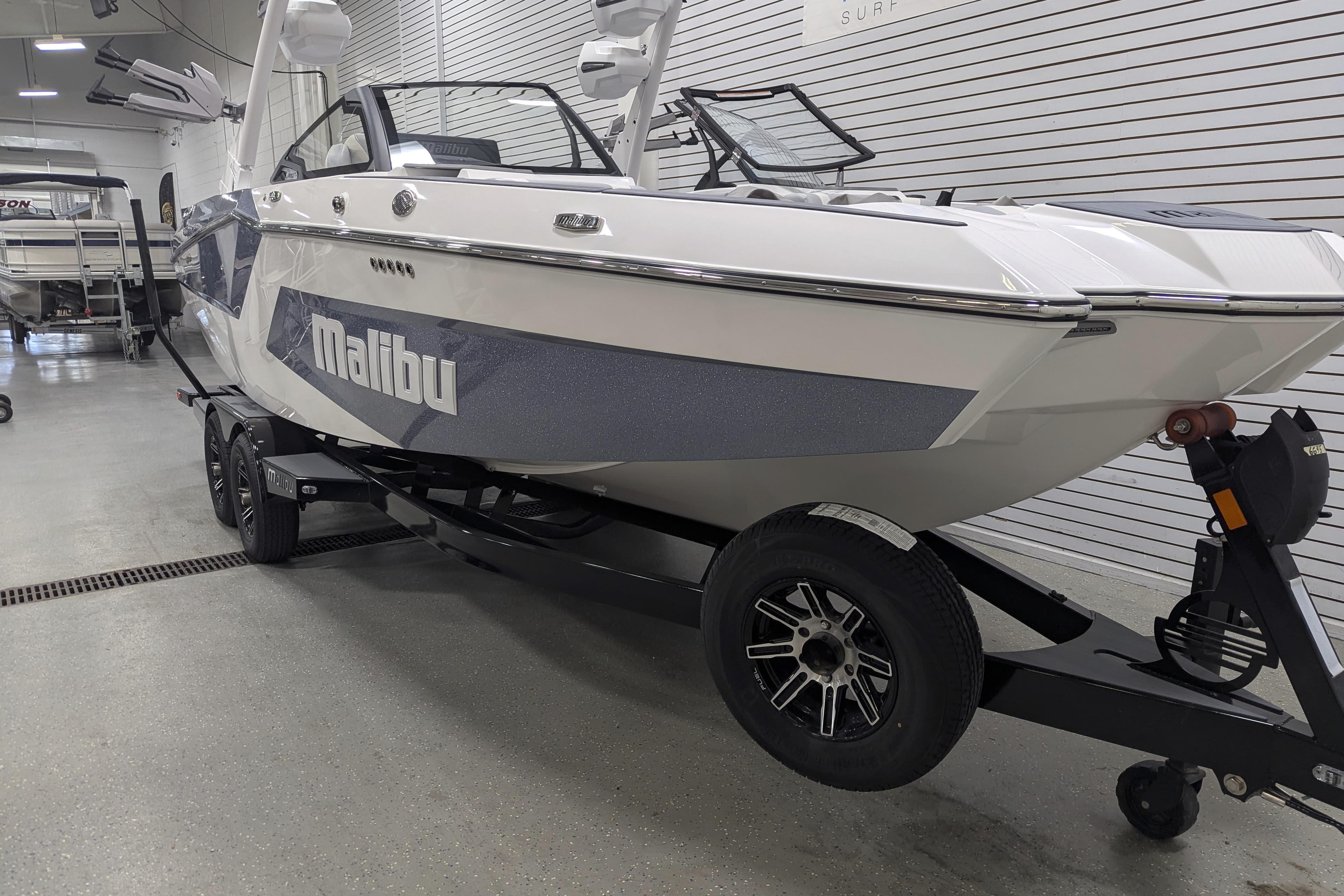 2025 Malibu Wakesetter 24 MXZ boat on trailer in showroom.