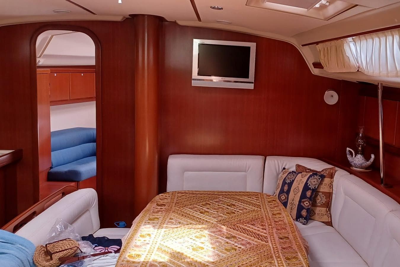 Interior of 2006 Dufour 455 Grand Large yacht with cozy seating and elegant wood finish.