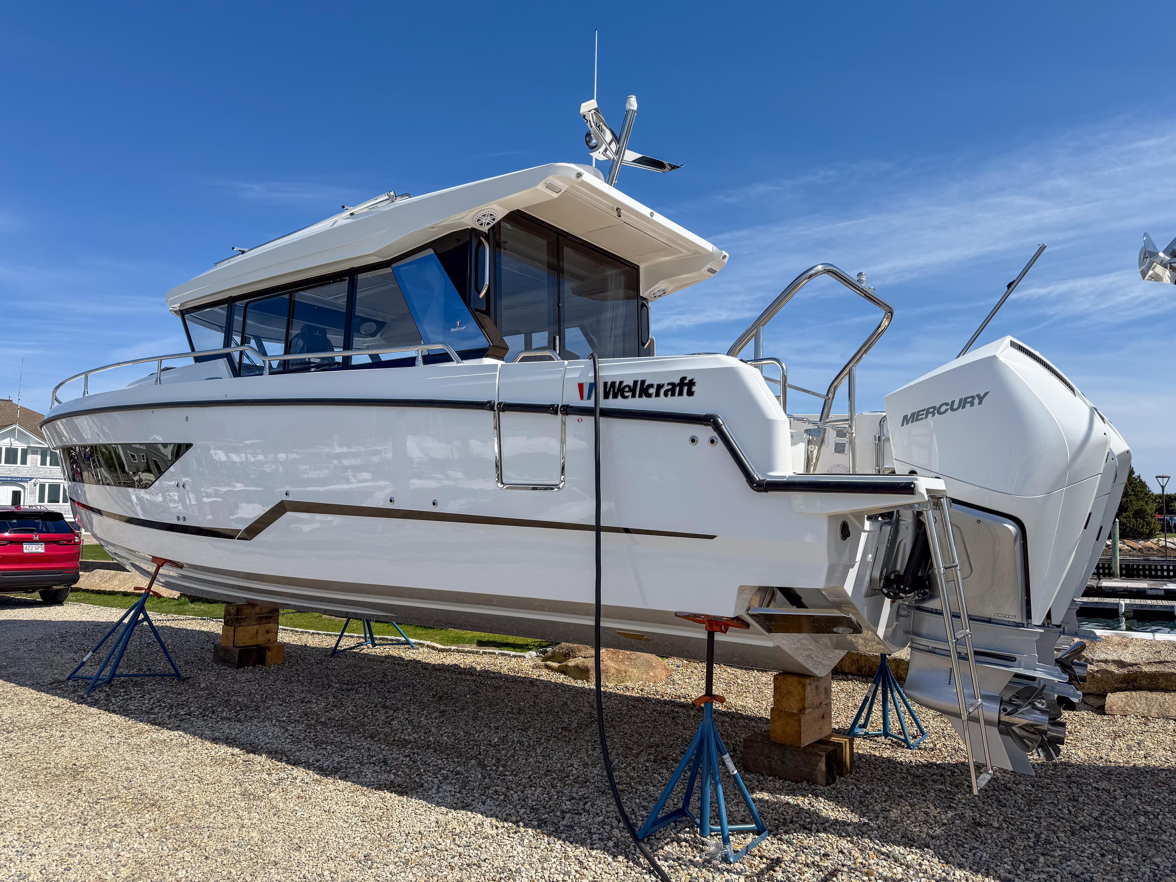 2025 Wellcraft 38 Explorer boat on stands, featuring sleek design and Mercury engines.