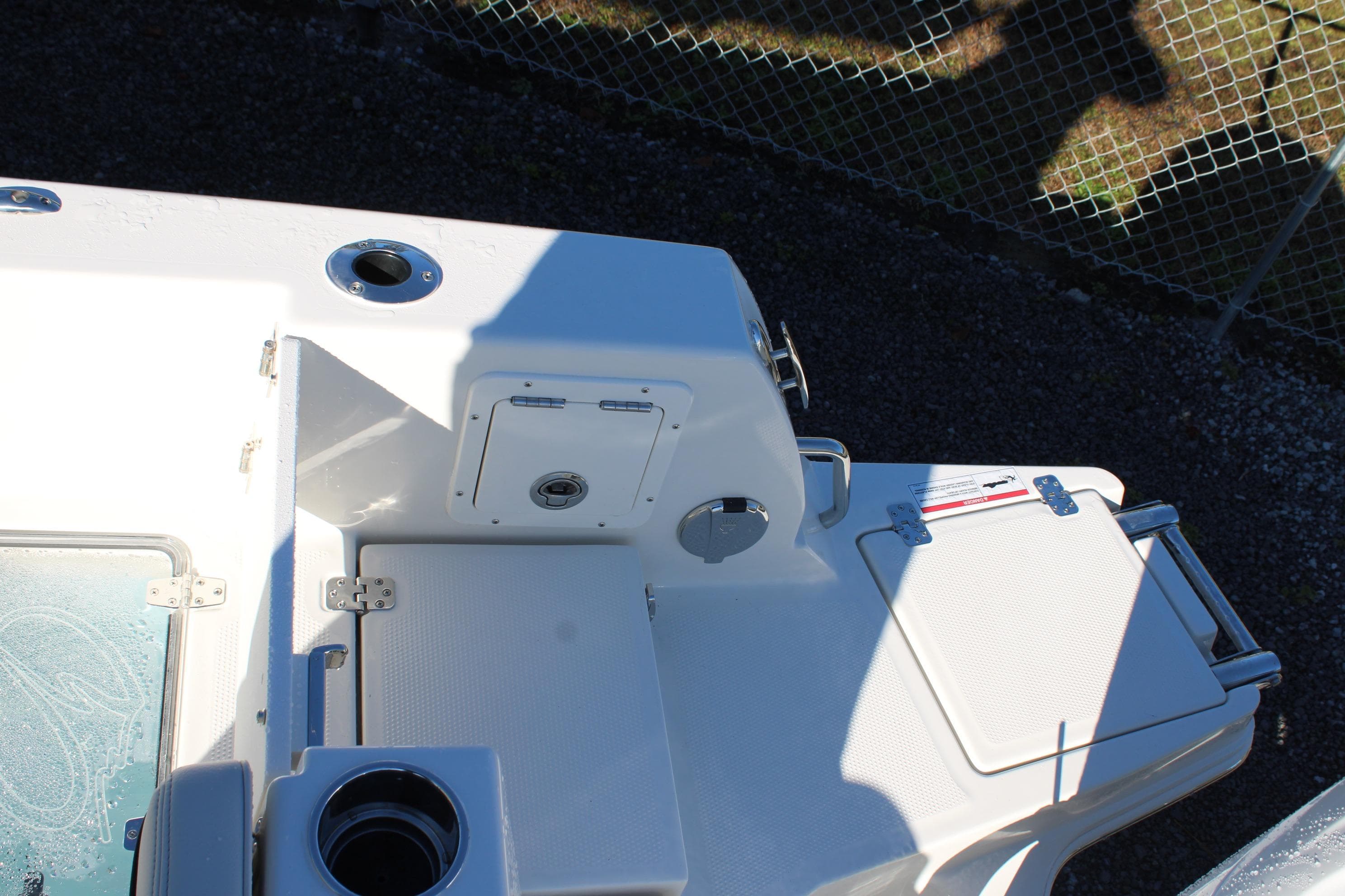 2026 Sailfish 252 CC boat deck with storage compartments and cup holder.
