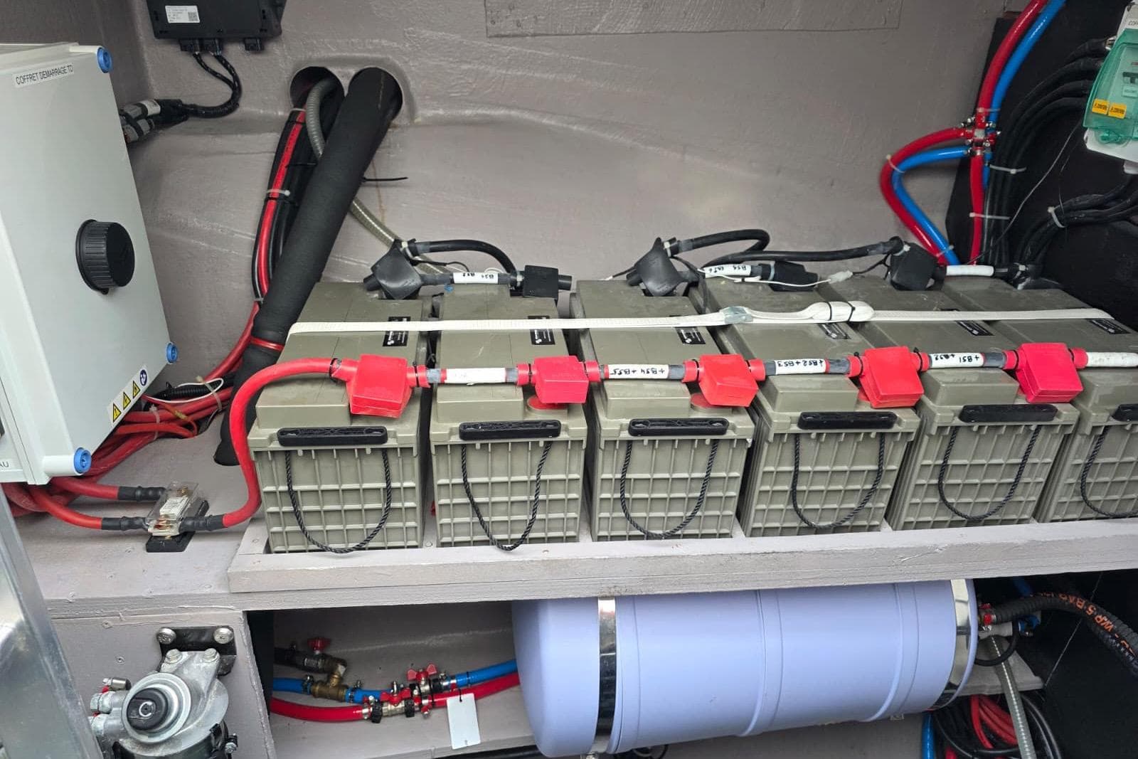 Battery compartment of a 2023 Bali 5.4 yacht with multiple connected batteries.